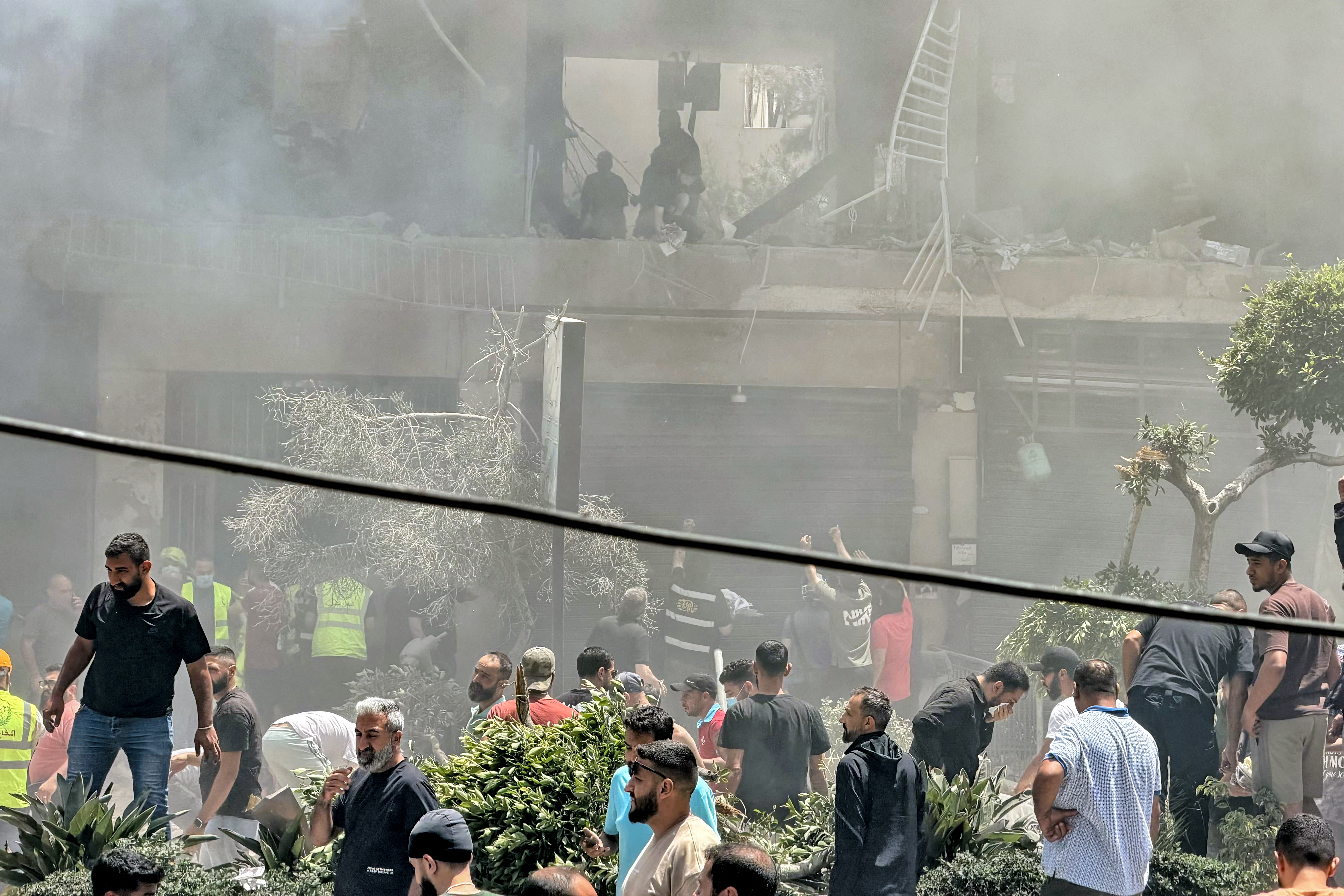 People look for survivors at the site of an Israeli airstrike that targeted a building in Beirut's southern suburbs on Sunday. (Ibrahim Amro/AFP/Getty Images)