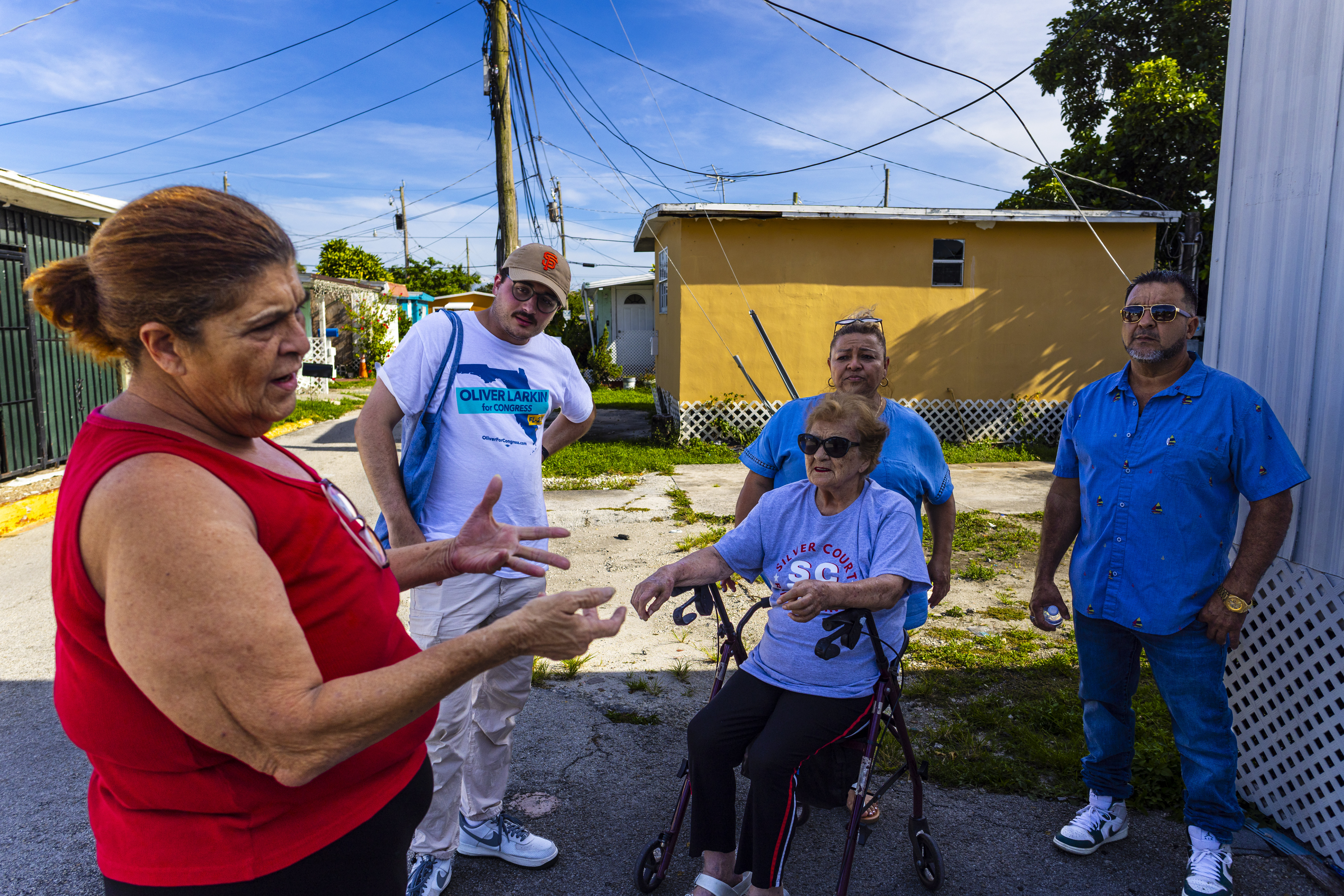 Oscar Alvarez, second from left, during a weekly meeting with the Silver Court mobile home park residents in Miami on June 5. (Saul Martinez/for The Washington Post )