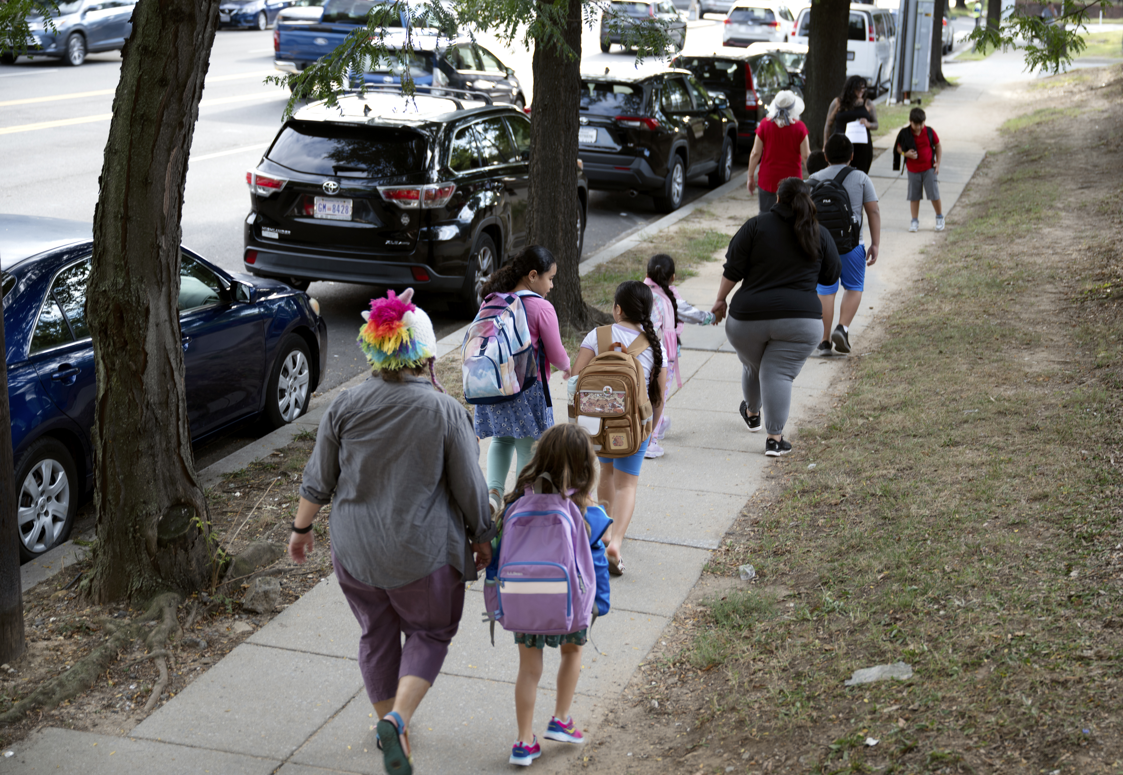 Parents form a “walking school bus” as they escort students to their elementary school in Washington in August 2025. (Marvin Joseph/The Washington Post)