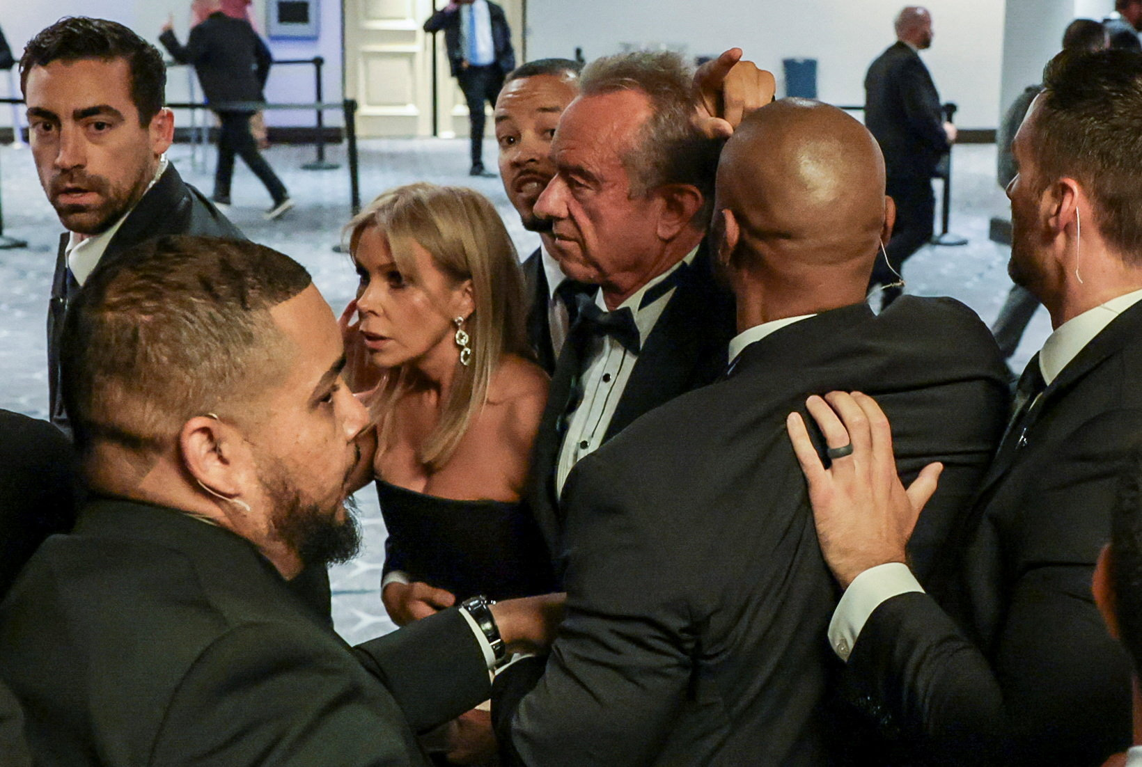 HHS Secretary Robert F. Kennedy Jr. and wife Cheryl Hines are hustled out of the White House correspondents' dinner on Saturday after a gunman tried to rush the room. (Jonathan Ernst/Reuters)