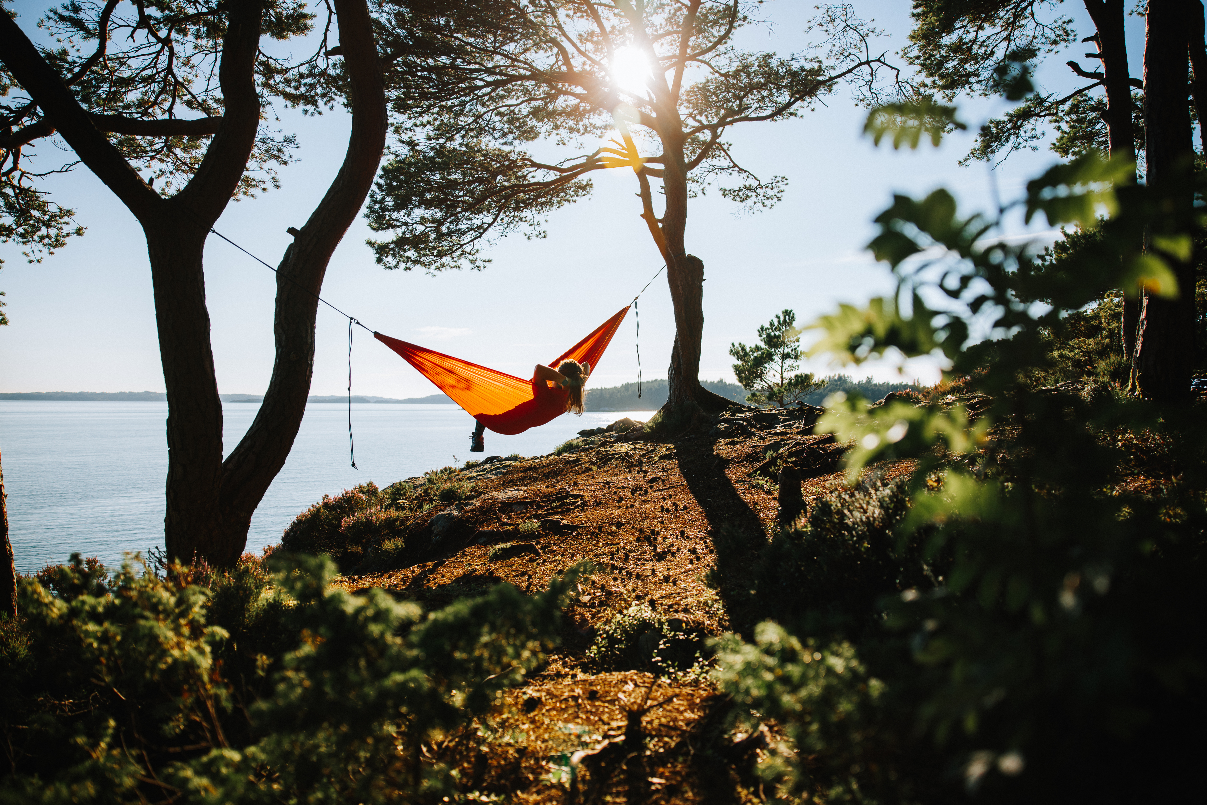 This person spends their leisure time in a hammock while overlooking water. (iStock)