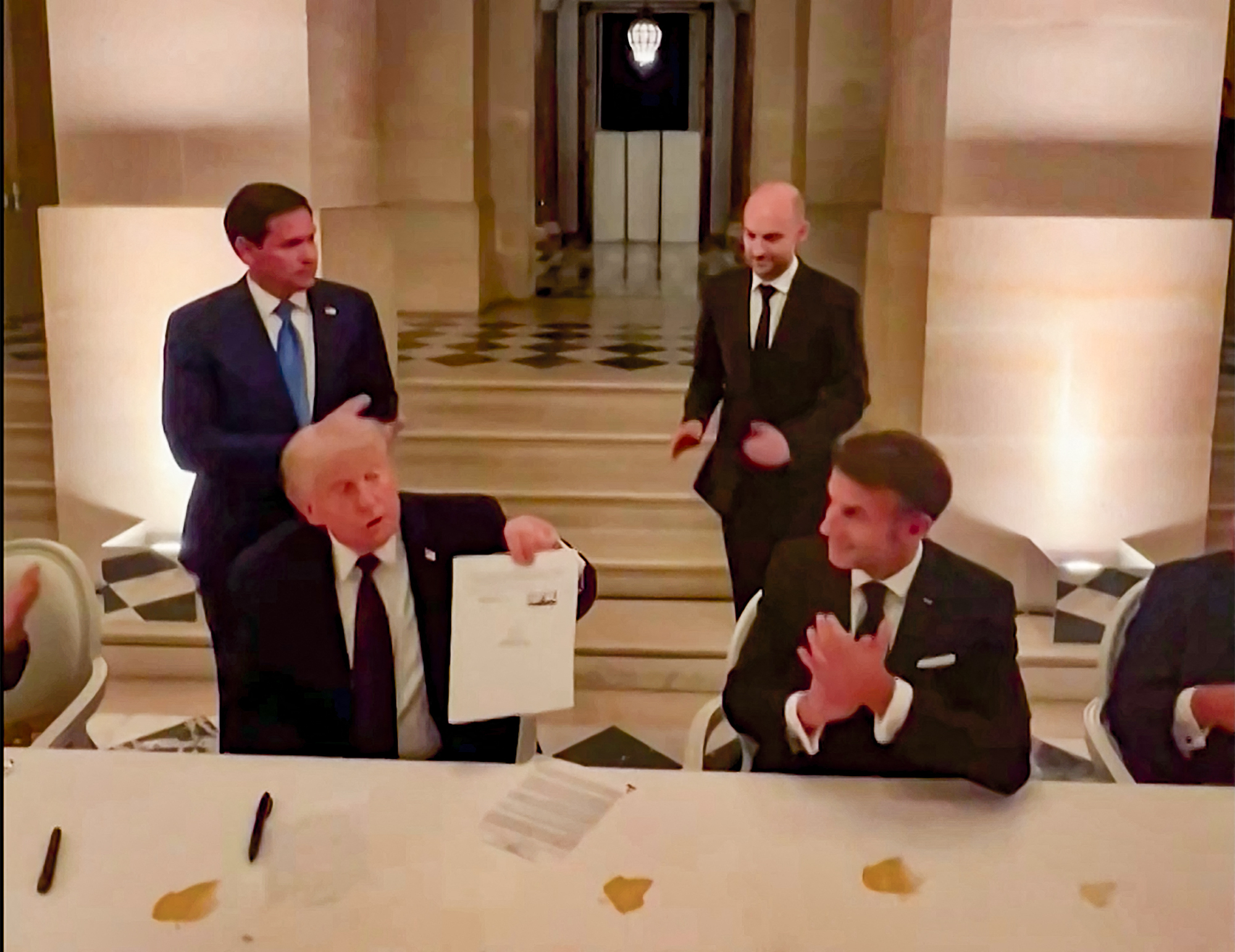 U.S. President Donald Trump and French President Emmanuel Macron during the signing to end the war in Iran. (AFP/Getty Images)