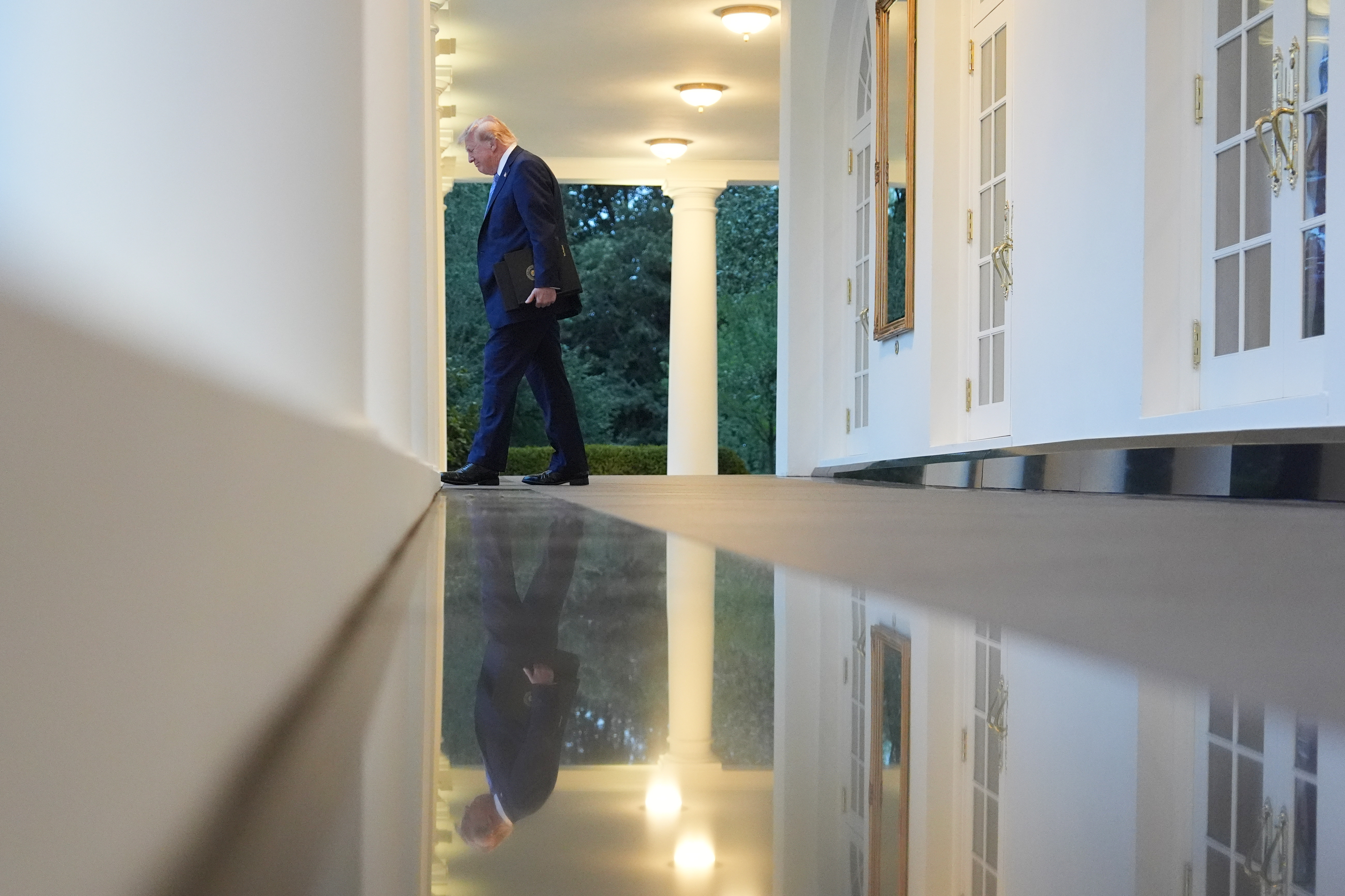 President Donald Trump walks along the colonnade to attend a dinner in the Rose Garden at the White House on Thursday. (Alex Brandon/AP)
