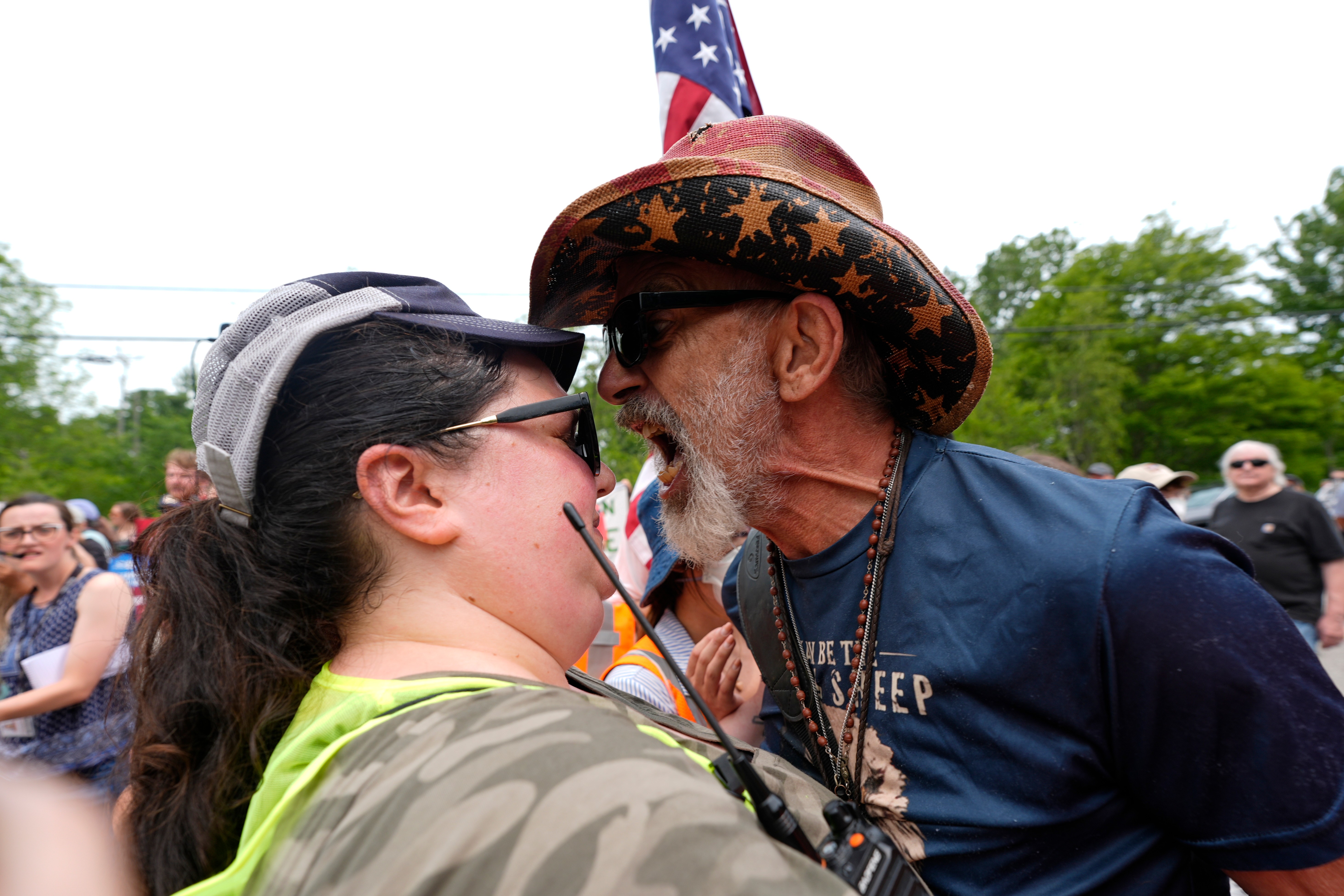 A man yells at a woman working security near an ICE facility Tuesday in Scarborough, Maine, one day after a fatal shooting in nearby Biddeford. (Robert F. Bukaty/AP)