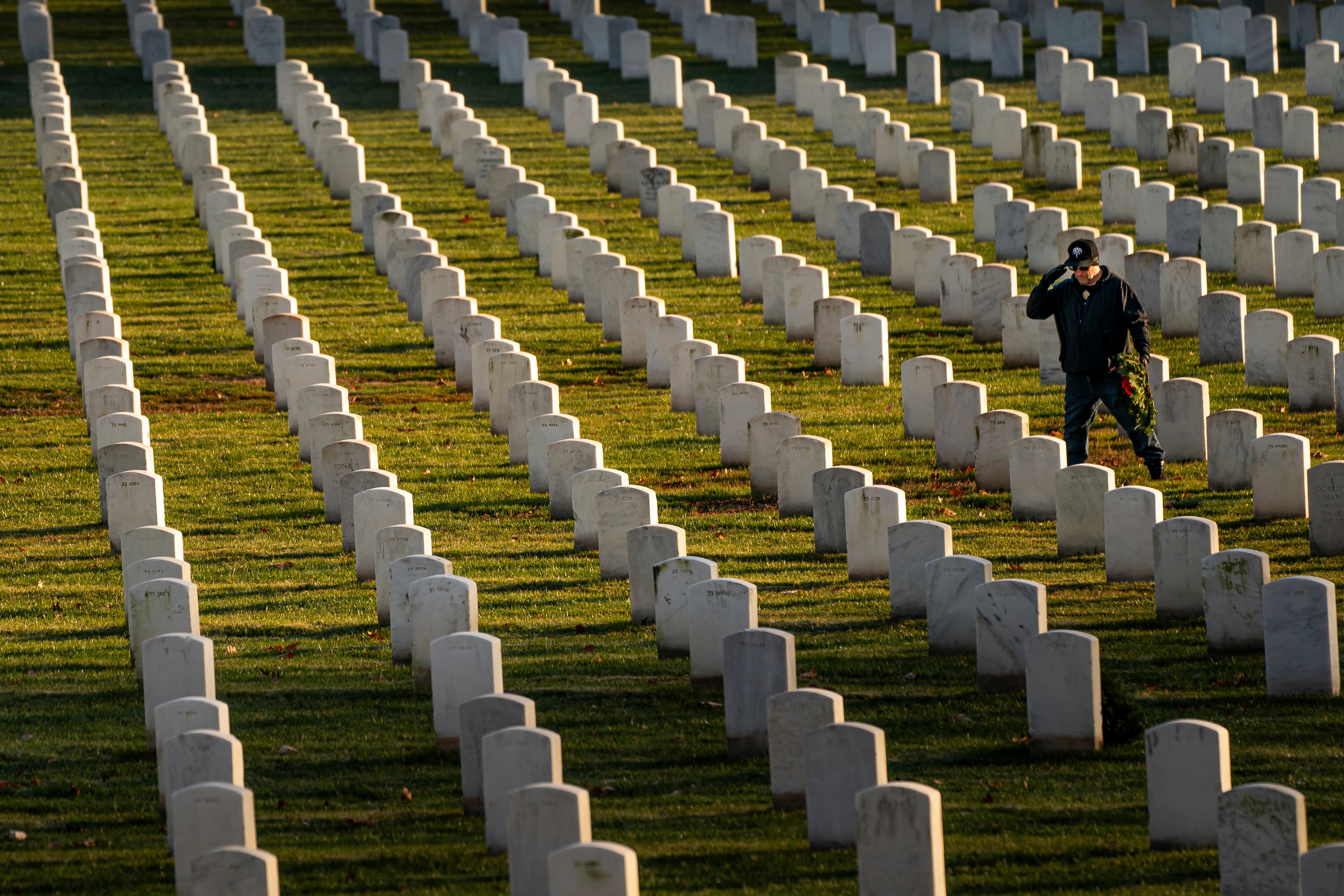 A man salutes after placing a wreath at Arlington National Cemetery in December 2023. (Nathan Howard/AP)
