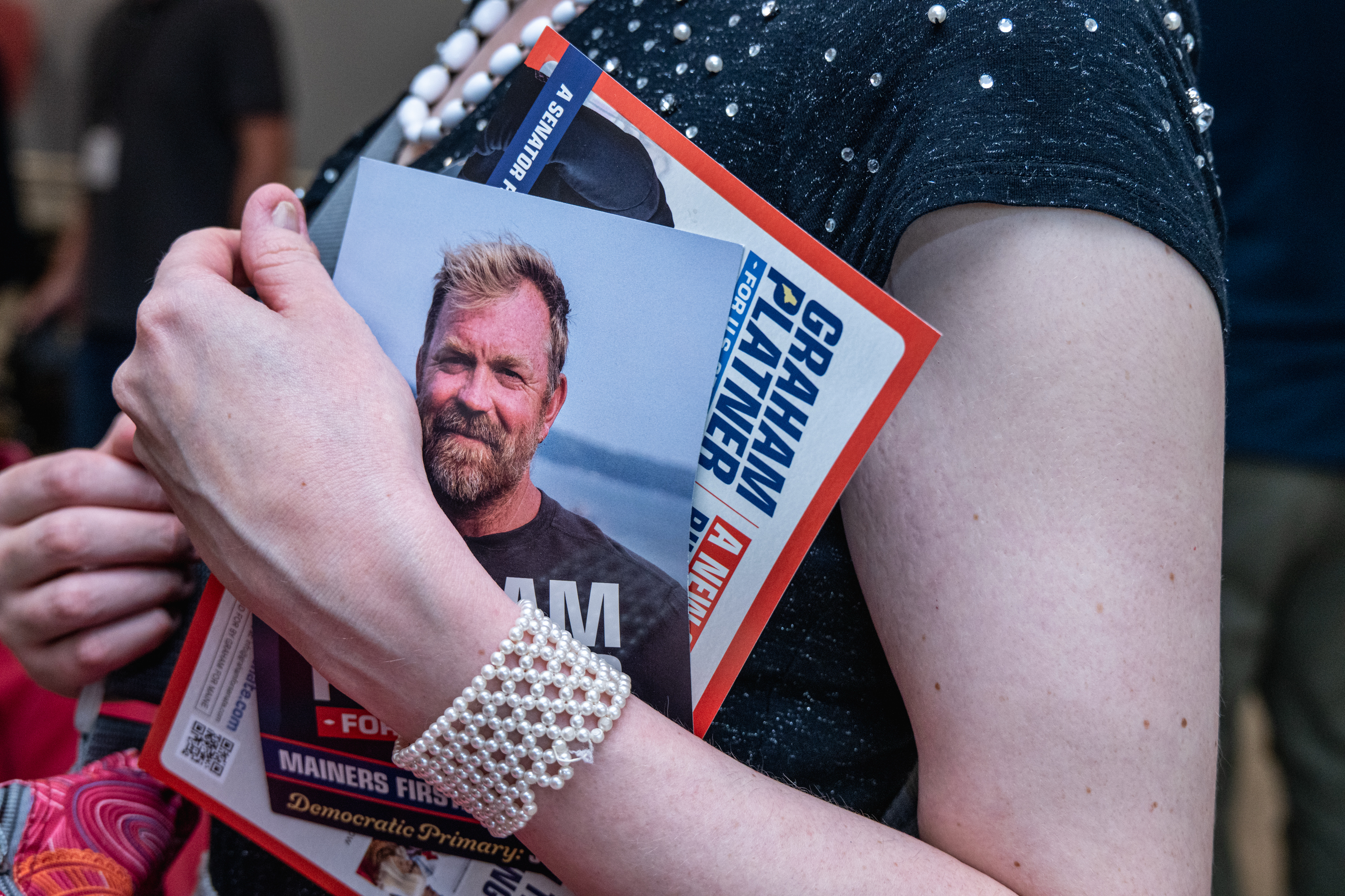 A Maine voter holds up a campaign flier for Democratic U.S. Senate candidate Graham Platner last month during a town hall in Portland. (Laura Brett/Getty Images)