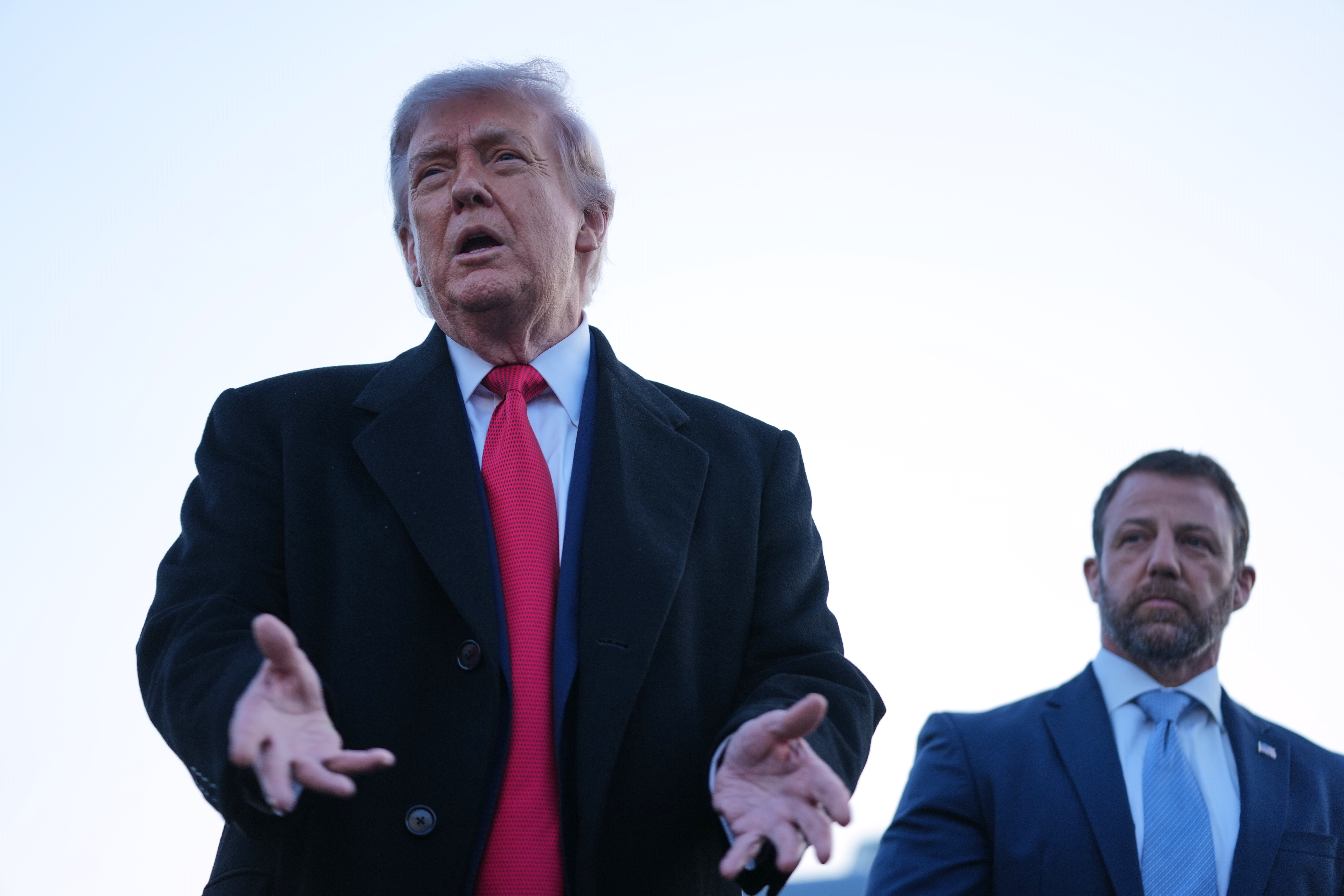 President Donald Trump speaks to reporters at the Reflecting Pool on Thursday alongside Homeland Security Secretary Markwayne Mullin. (Mark Schiefelbein/AP)