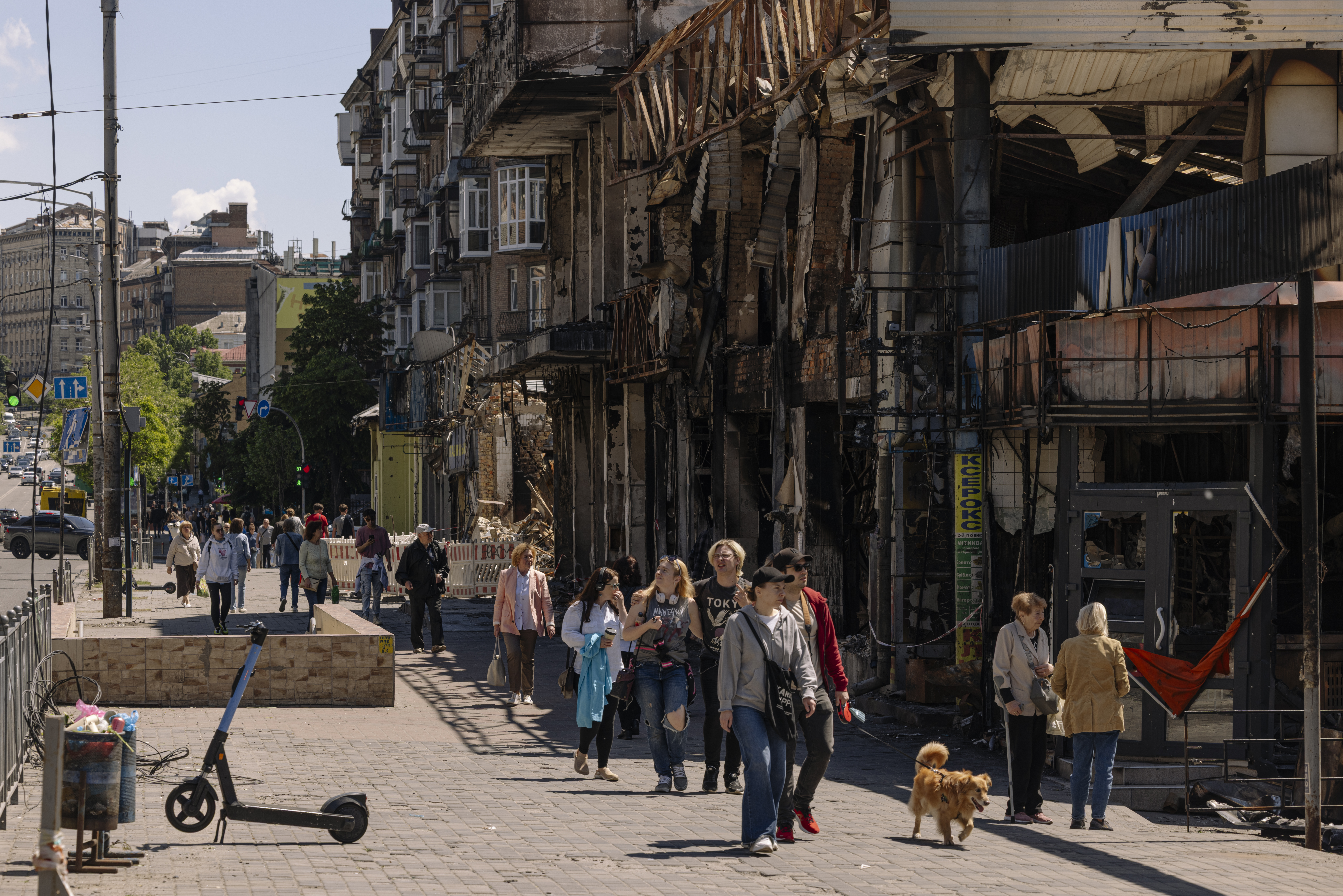 People walk past burned storefronts in the historic Lukianivskyi Market, a fixture since the 1880s. (Serhiy Morgunov/For The Washington Post)