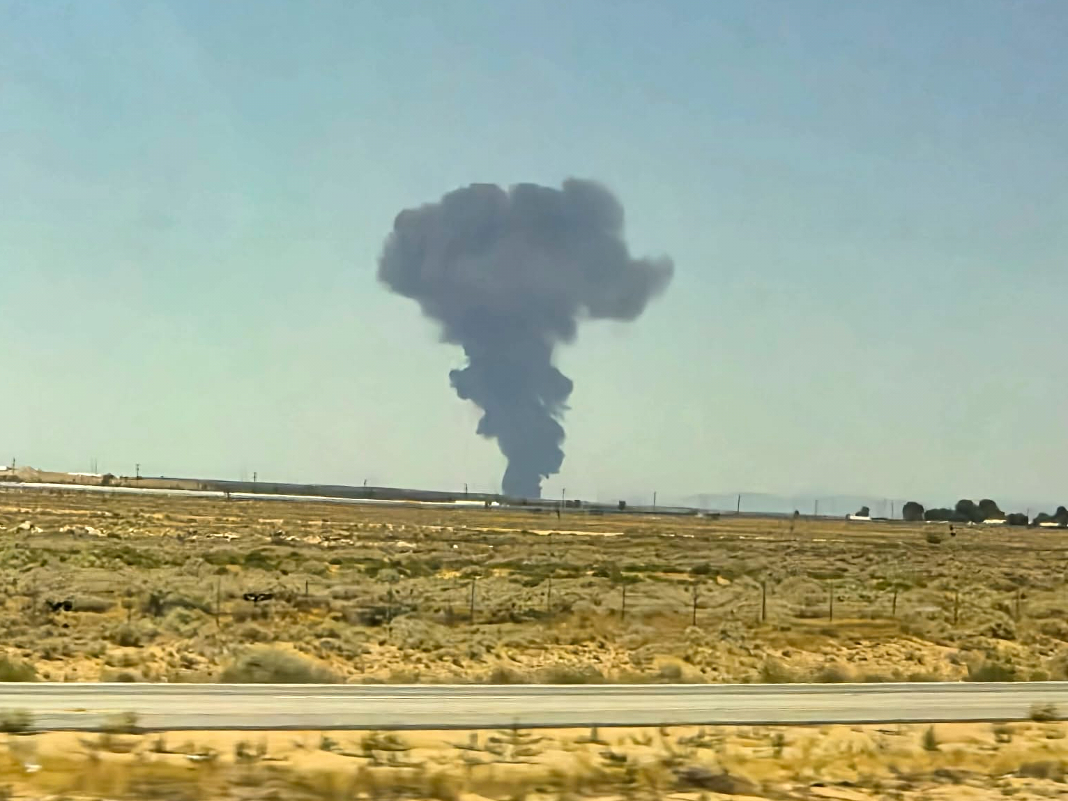 A smoke plume rises from the crash Monday. (Debbie Reyes Katz/via AP)
