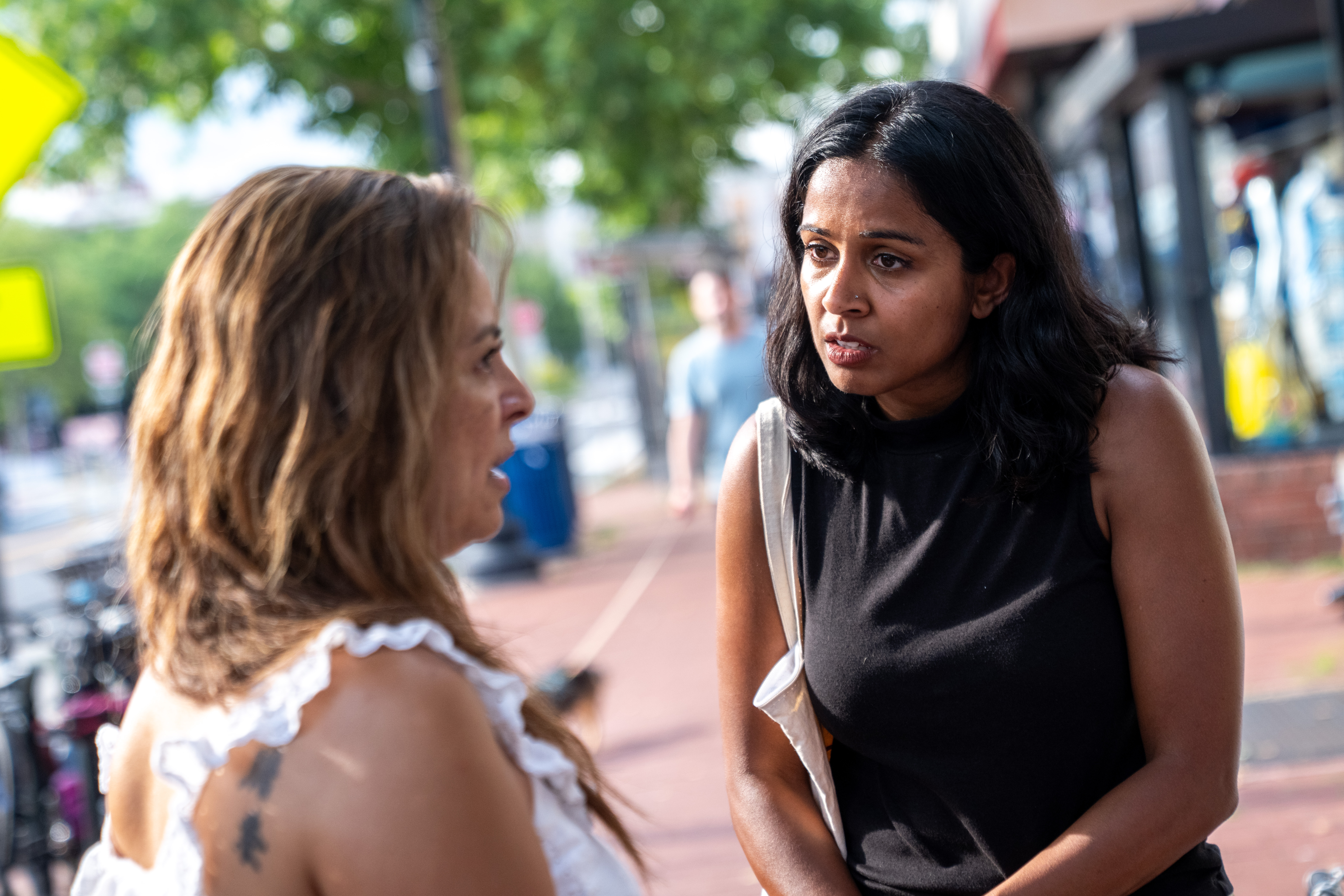 Aparna Raj, right, the Democratic nominee for Ward 1 on the D.C. Council, speaks to chef and restaurant owner Patrice Cleary in July. (Allison Robbert/For The Washington Post)