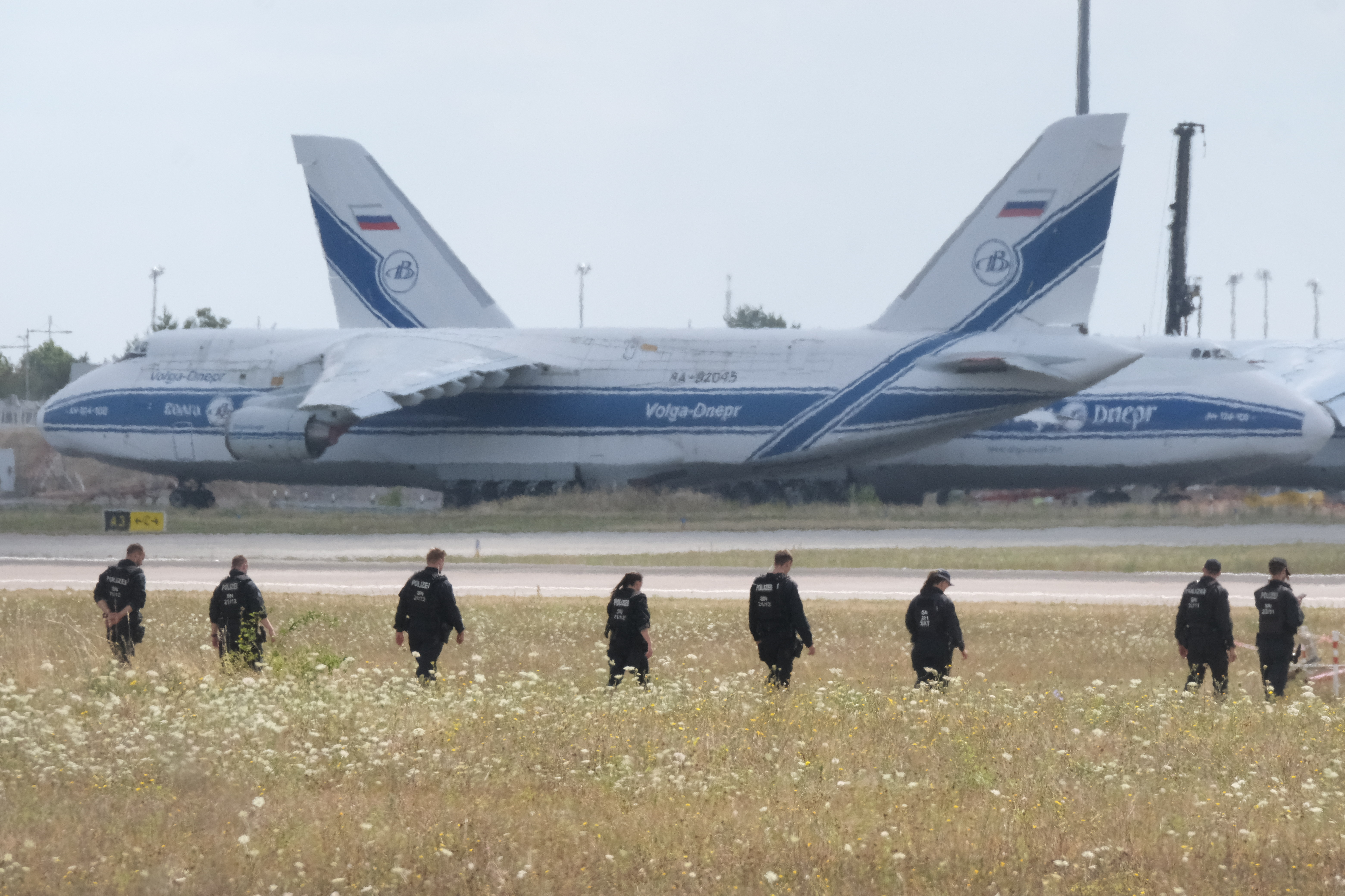 Police officers walk across a field at Leipzig/Halle Airport in Germany three days after a drone attack last month. (Sebastian Willnow/DPA/AP)