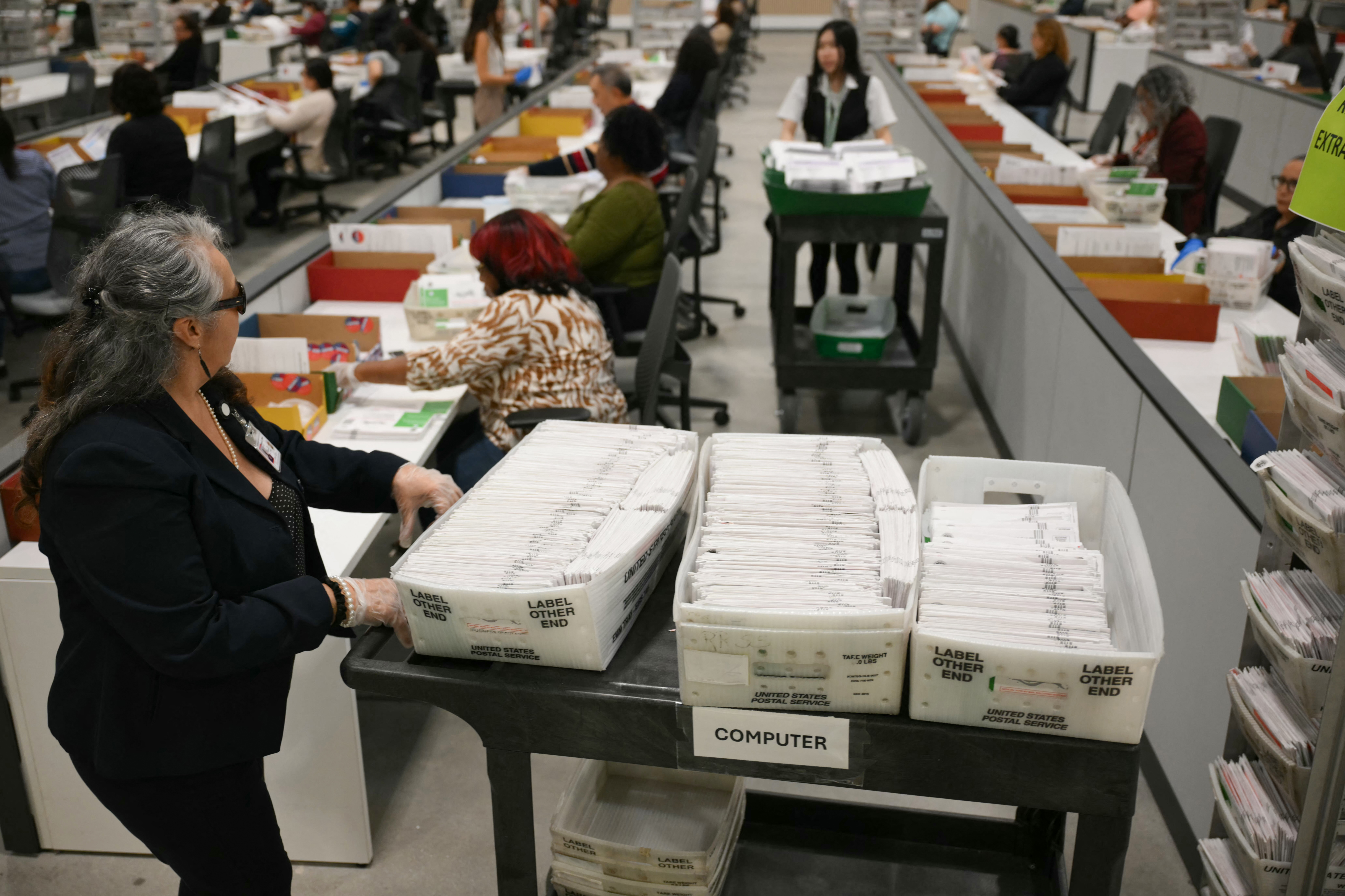 An election worker moves mail-in ballots to be organized for tabulation on June 2 at the Los Angeles County Ballot Processing Center in Industry, California. (Patrick T. Fallon/AFP/Getty Images)