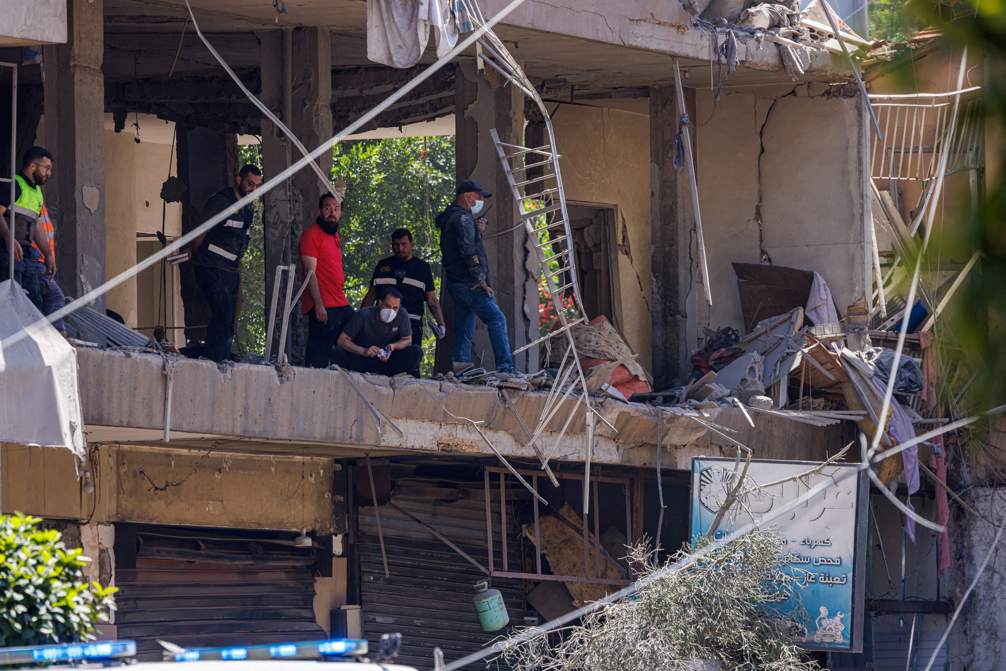 Police officers and emergency personnel work at the site of an Israeli strike in the southern suburbs of Beirut on Sunday. (Zohra Bensemra/Reuters)