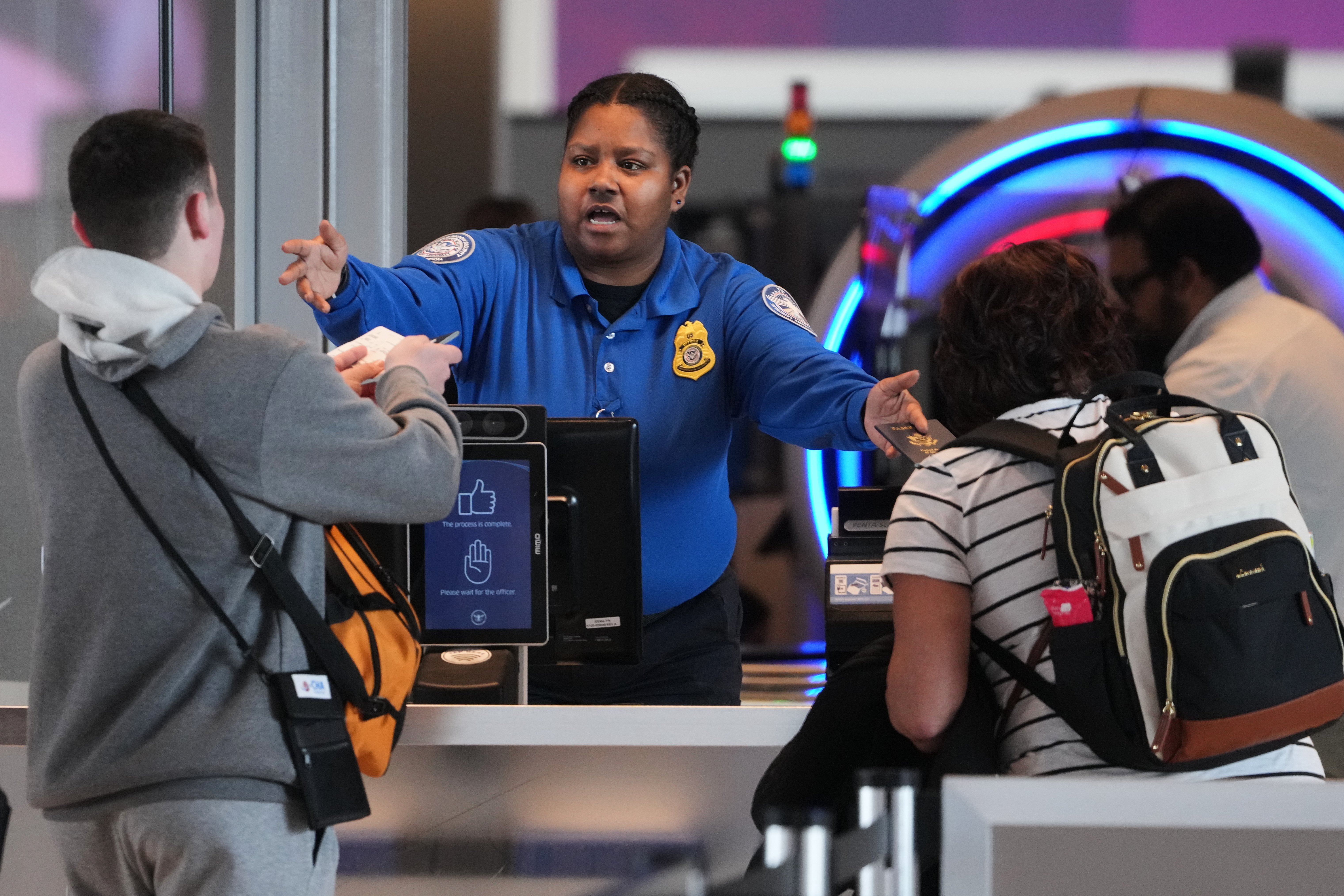 A TSA worker checks passengers Thursday at Pittsburgh International Airport. (Gene J. Puskar/AP)