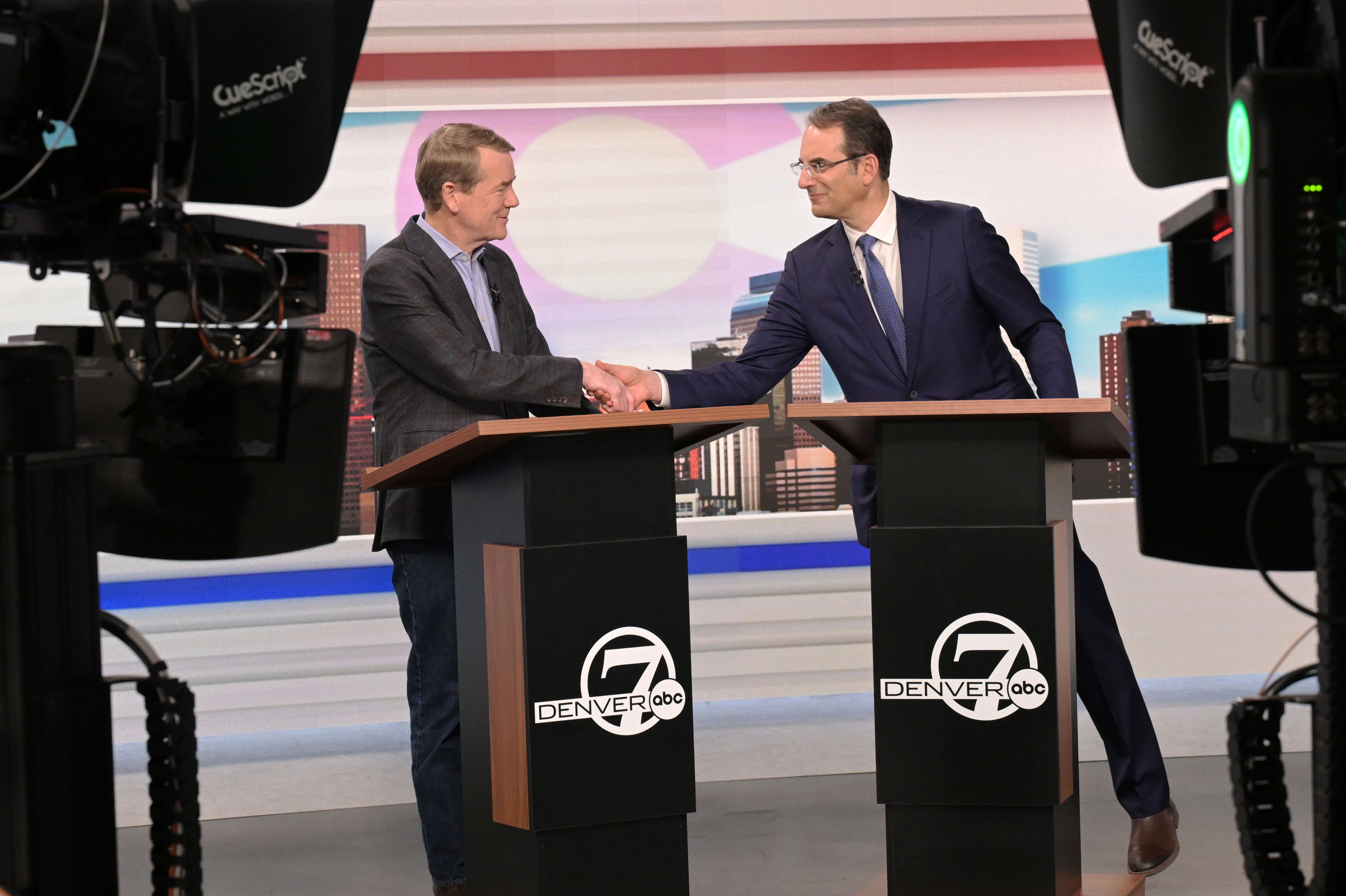 Sen. Michael Bennet, left, and Attorney General Phil Weiser shake hands after a debate May 7 in Denver. (RJ Sangosti/MediaNews Group/Denver Post/Getty Images)