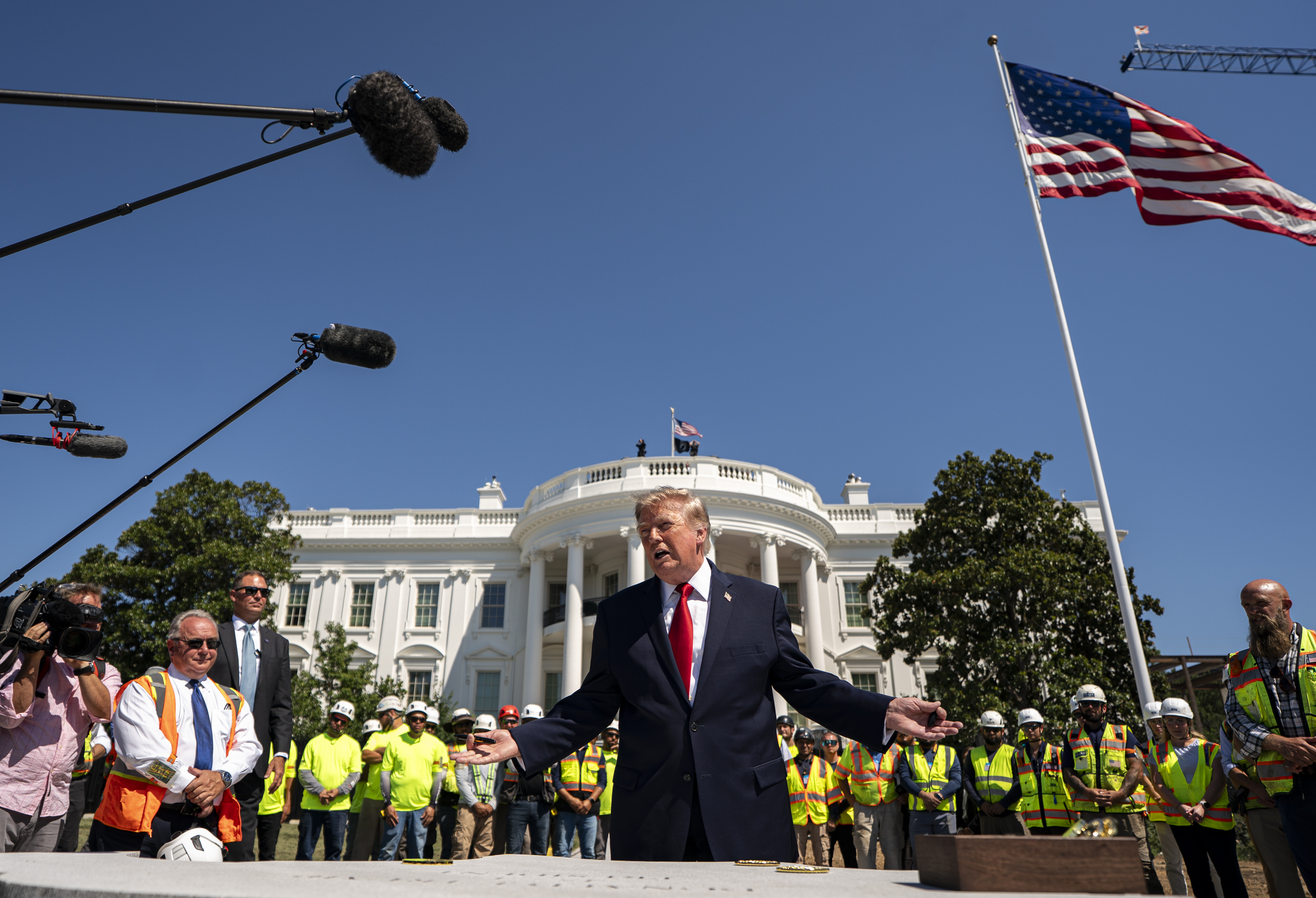 President Donald Trump stands with workers near the South Lawn's under-construction helipad on Aug. 19. (Al Drago/Pool/For The Washington Post)