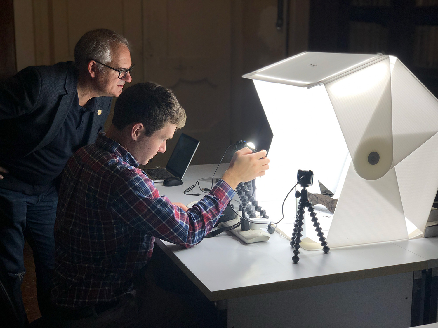 Brent Seales, left, and a colleague scan a Herculaneum scroll at Diamond Light Source. (EduceLab)