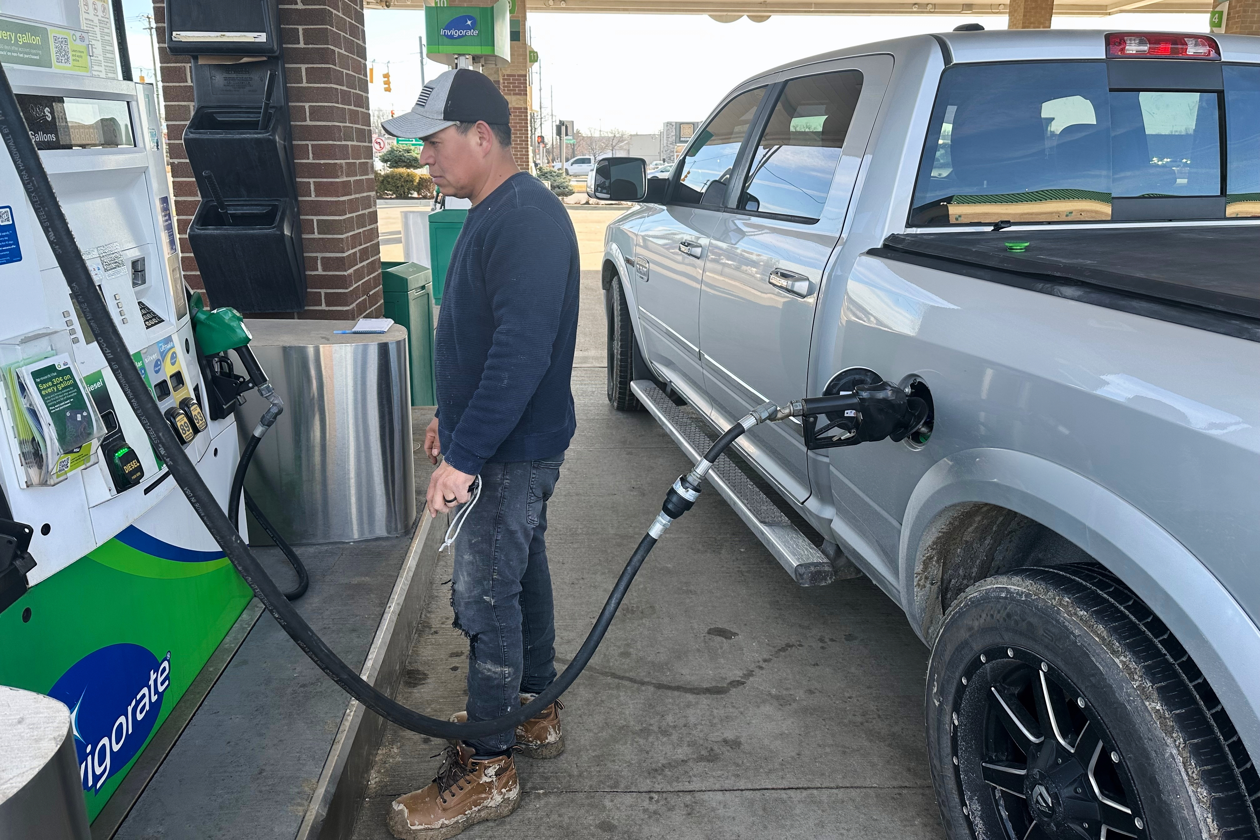 Josue Hernandez, 35, pumps gas into his work pickup truck at a station in Southfield, Michigan, this month. (Corey Williams/AP)