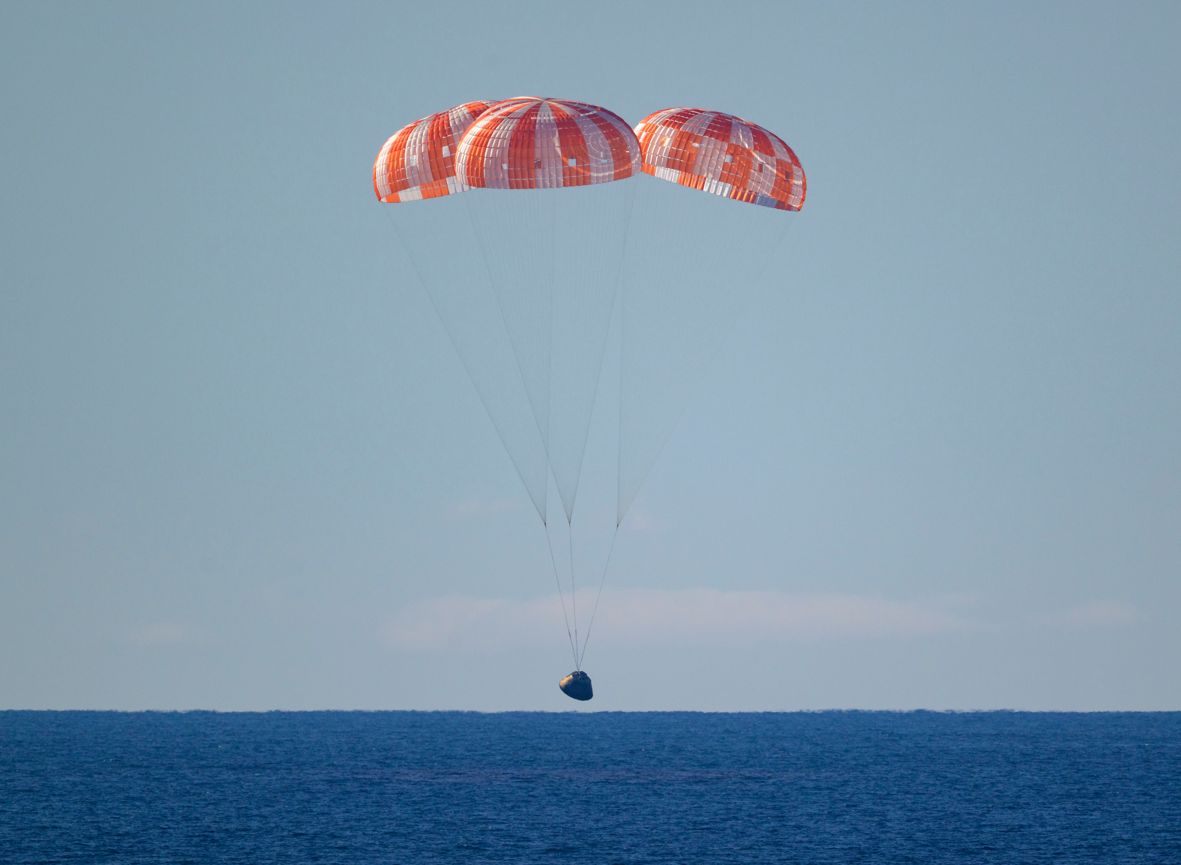 The Orion module with the Artemis II crew members aboard splashes down in the Pacific Ocean off the coast of California. (Bill Ingalls/NASA/AP)