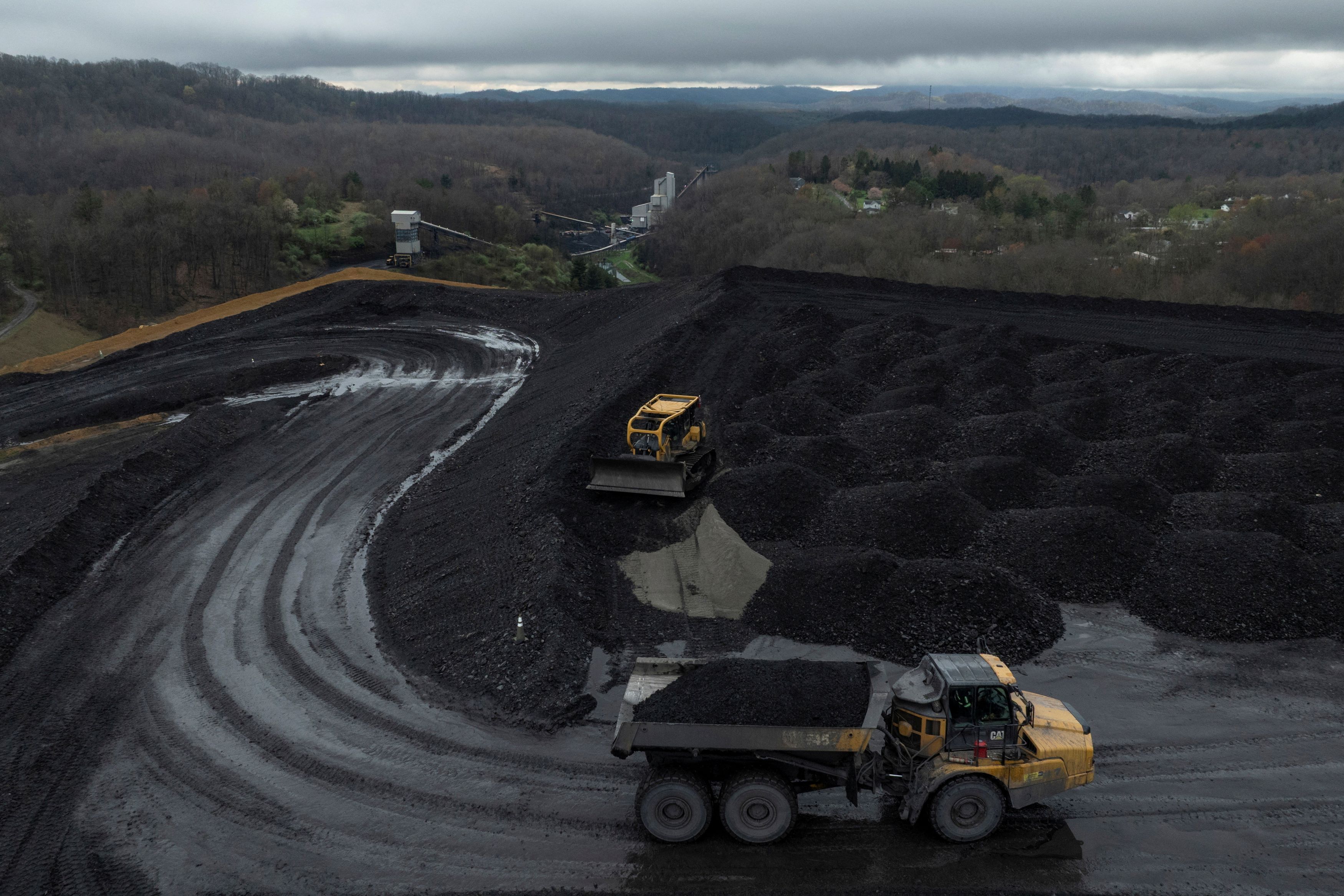 Workers transport and organize mounds of coal on a hilltop near a facility in Beckley, West Virginia, in 2025. (Adrees Latif/Reuters)