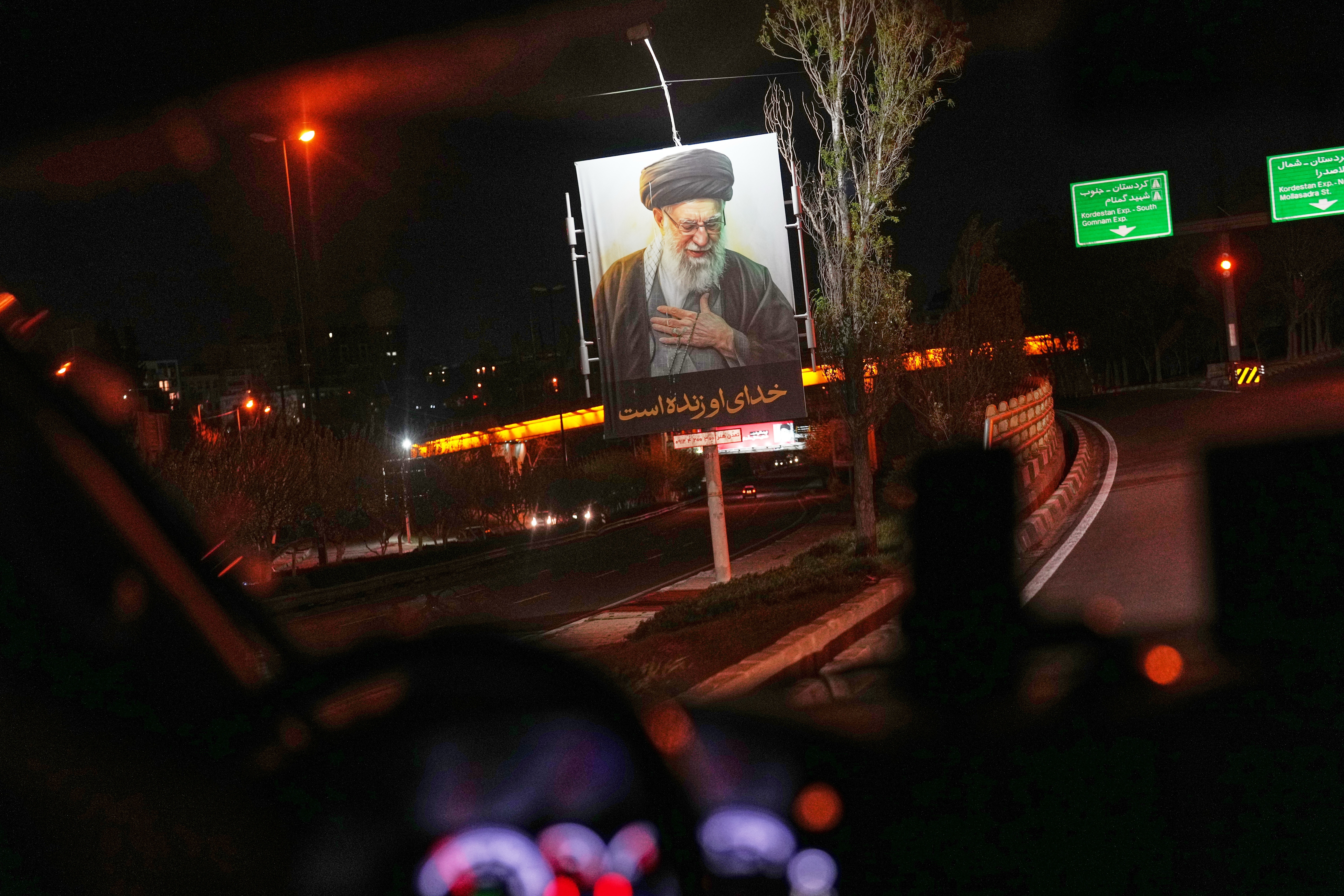A picture of the late Iranian supreme leader Ali Khamenei hangs on the side of the road in the outskirts of Tehran on April 5. (Francisco Seco/AP)