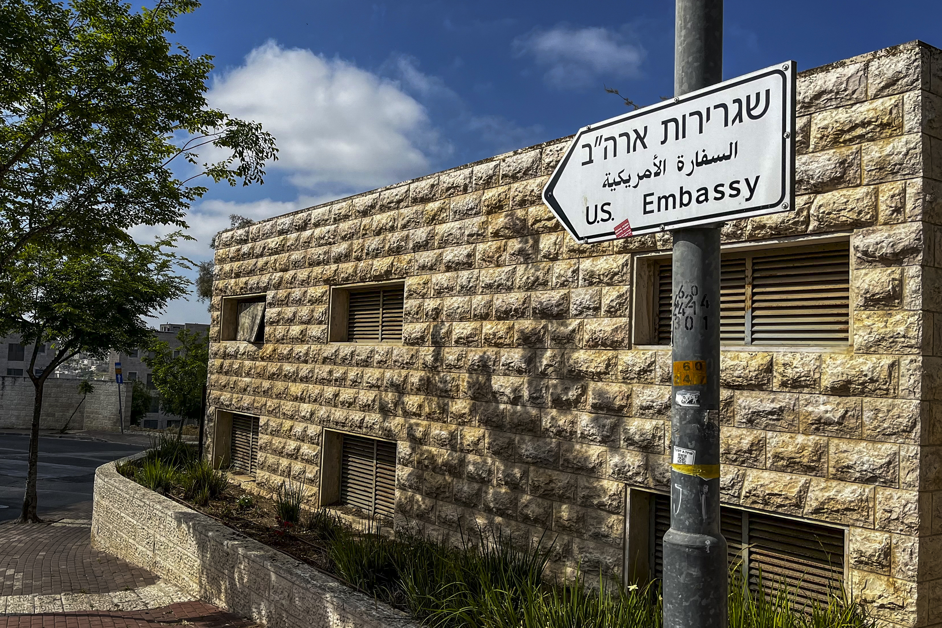 A road sign shows the way toward the U.S. Embassy in Jerusalem. On Friday, the State Department authorized nonemergency staff and family members at the embassy to leave Israel, warning that they should consider acting “while commercial flights are available.” (Ronaldo Schemidt/AFP/Getty Images)