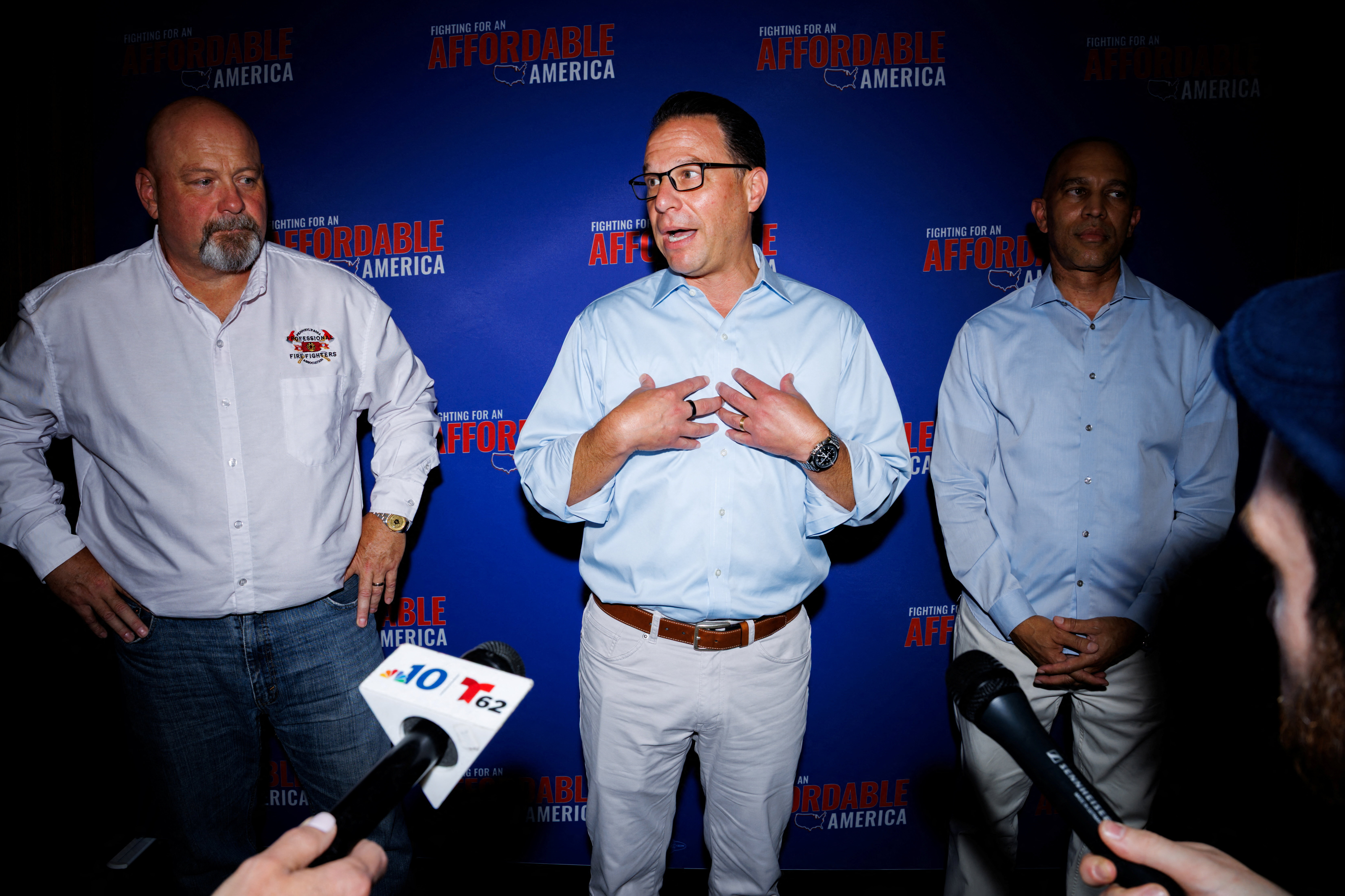 Pennsylvania Gov. Josh Shapiro (D), center, speaks to the press after an event last month to mark 100 days until the midterms. With him are congressional candidate Bob Brooks, left, and House Minority Leader Hakeem Jeffries (D-New York). (Hannah Beier/Reuters)