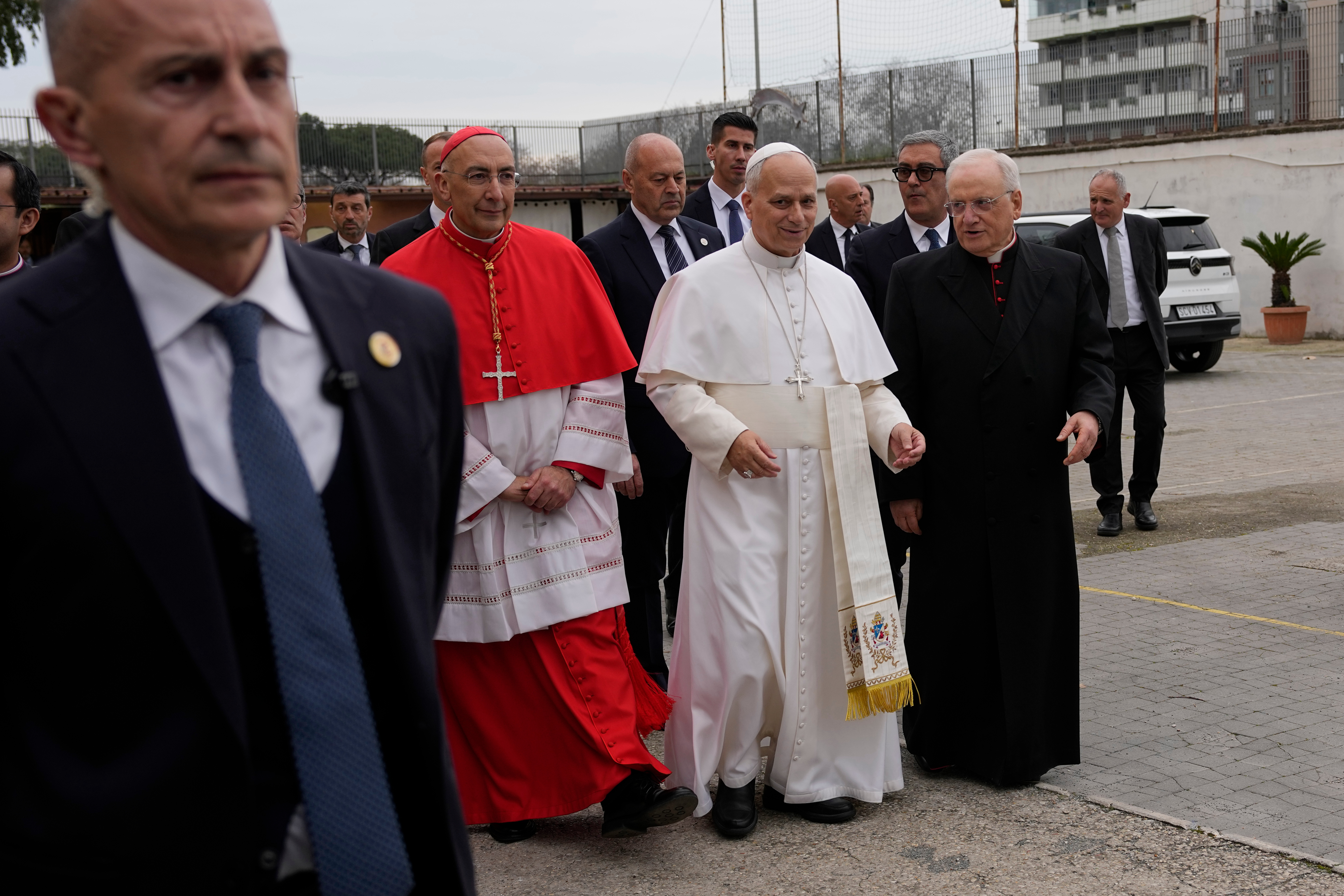 Pope Leo XIV is accompanied by Cardinal Baldassare Reina, left, and Monsignor Leonardo Sapienza as he visits the parish complex of the Ascension of Our Lord Jesus Christ on the outskirts of Rome on March 1. (Alessandra Tarantino/AP)