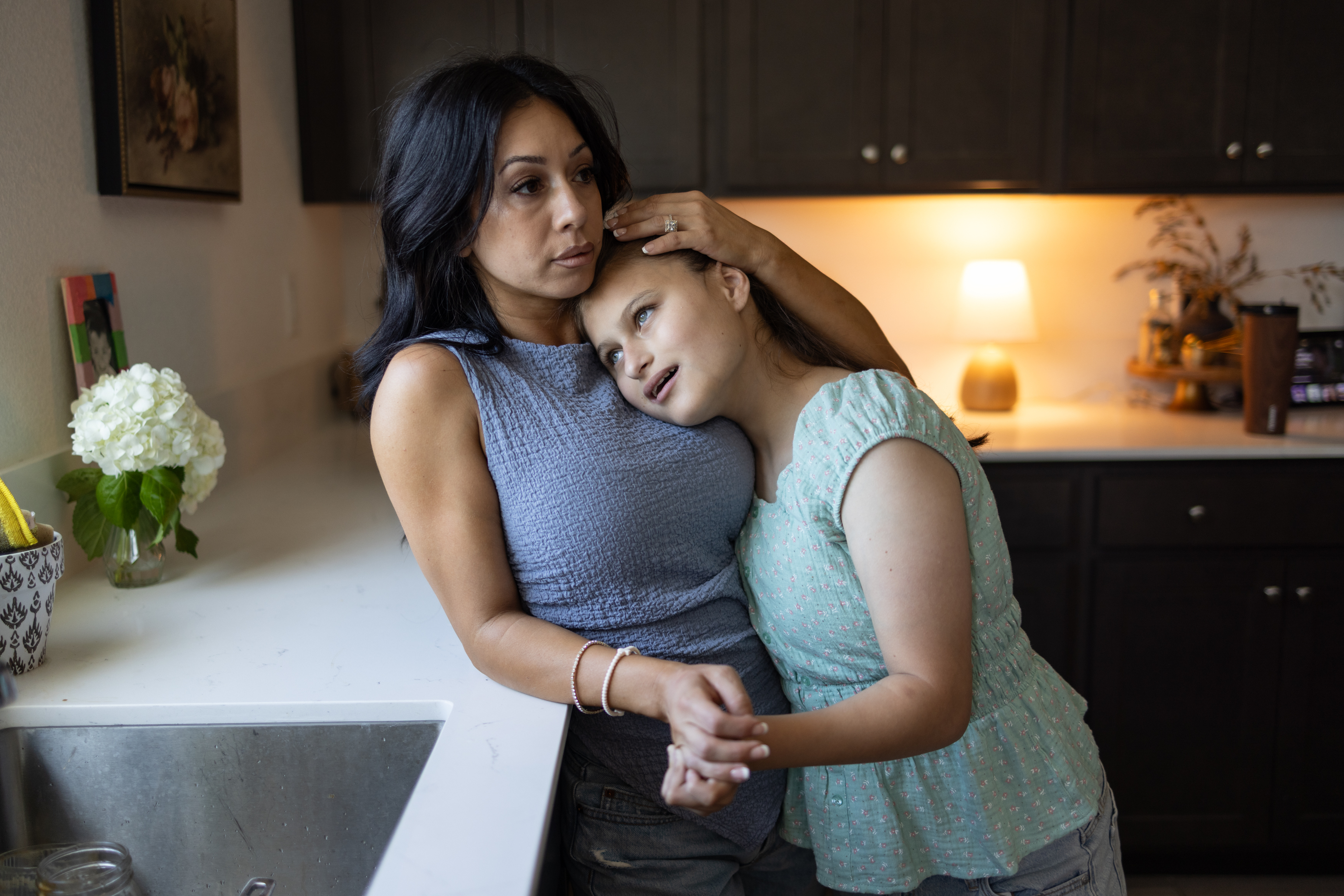 Annie comforts Ava in their kitchen. (Rachel Bujalski/For The Washington Post)