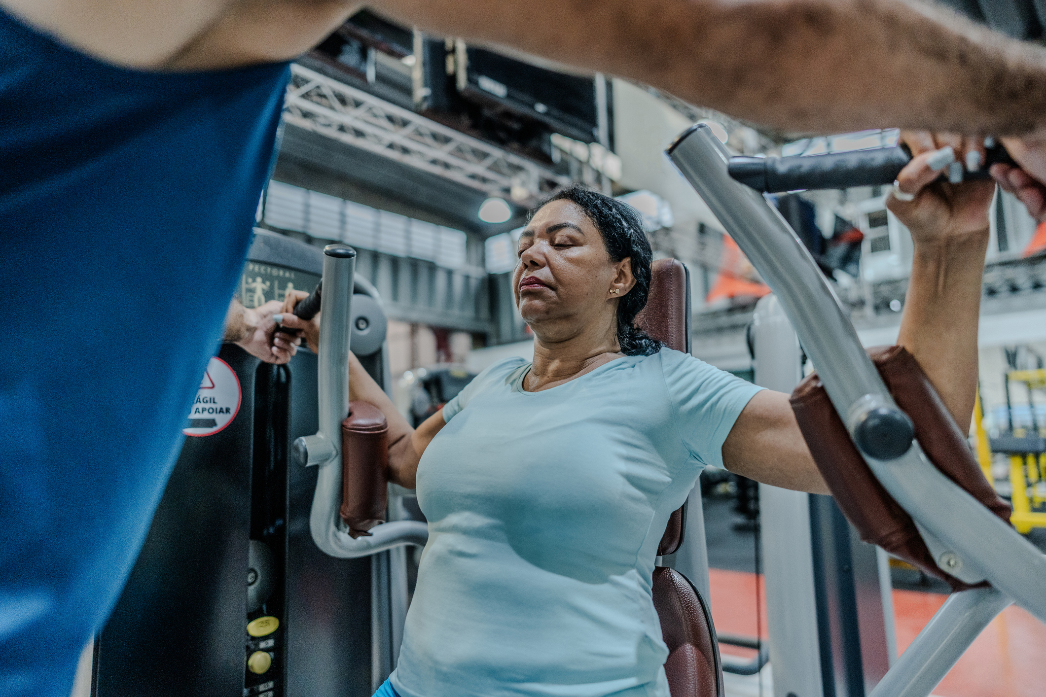Person performing a barbell deadlift in a gym with proper lifting form