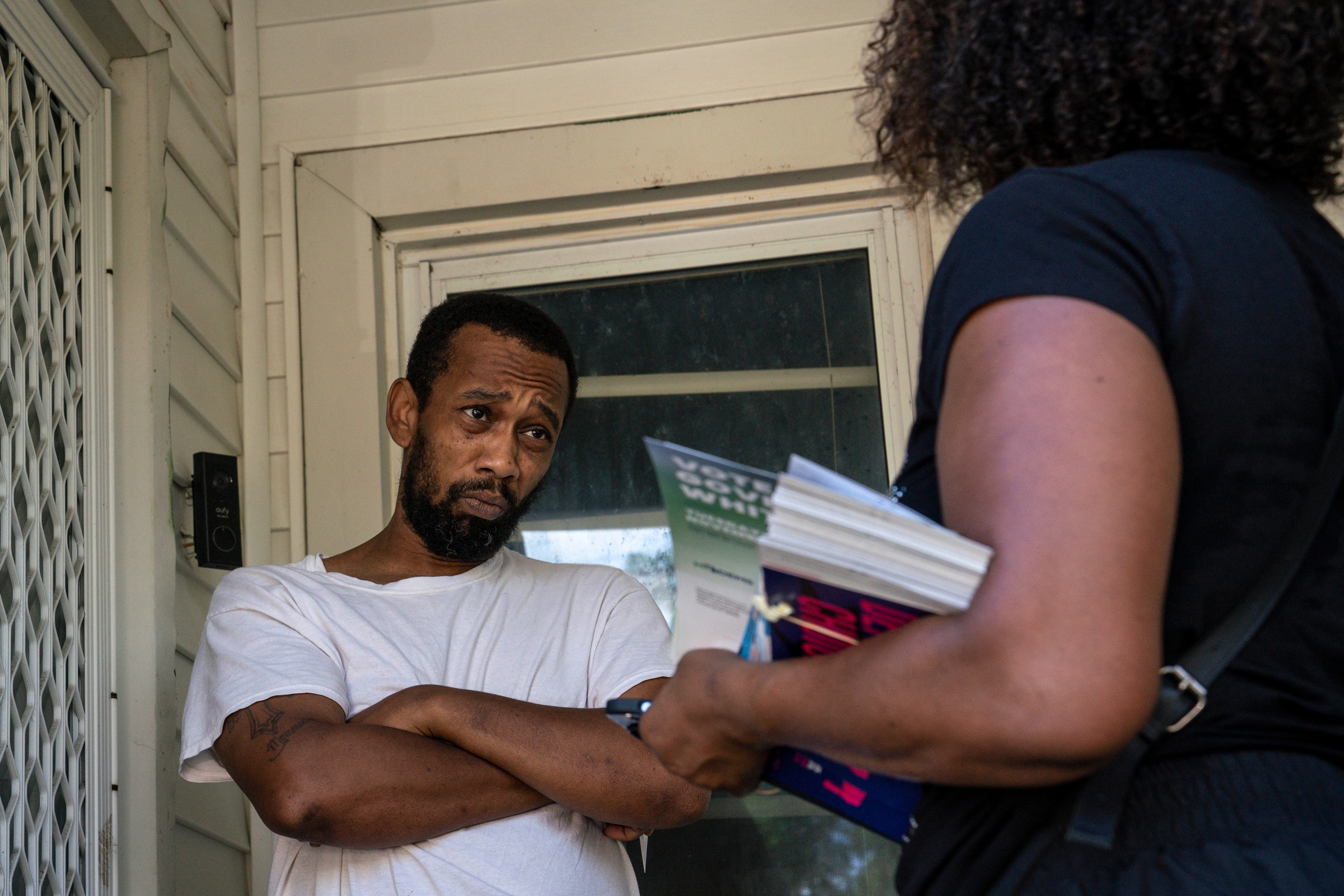 Brandon Cooper talks to volunteer Regina Campbell, right, about issues on the ballot in the fall of the 2022 campaign in Michigan. (Sarah Rice/For The Washington Post)