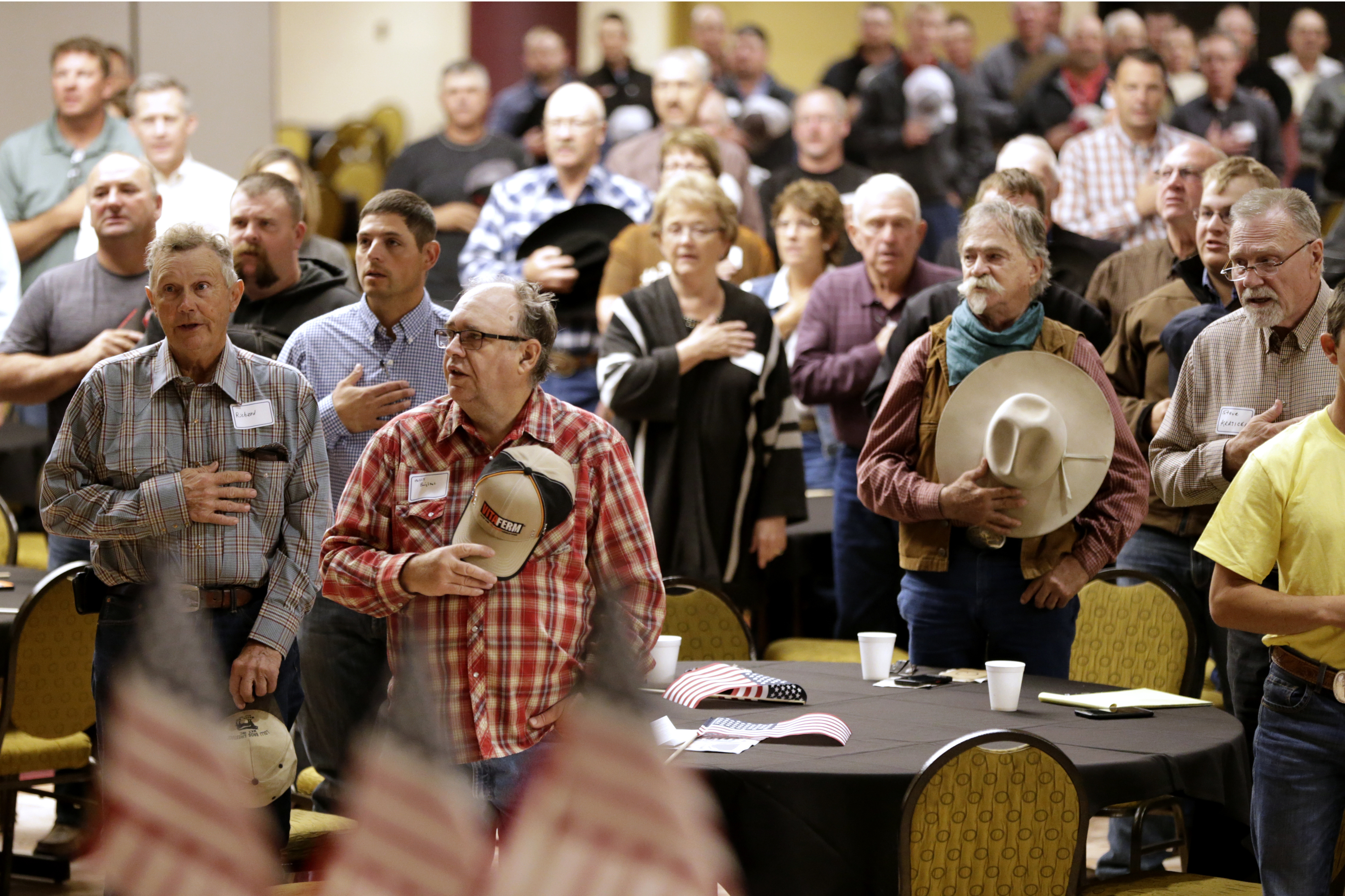 Farmers recite the Pledge of Allegiance in 2019 at the start of a meeting and rally in Omaha to urge President Donald Trump and then-Agriculture Secretary David Perdue to ensure fair prices for farmers and ranchers. (Nati Harnik/AP)