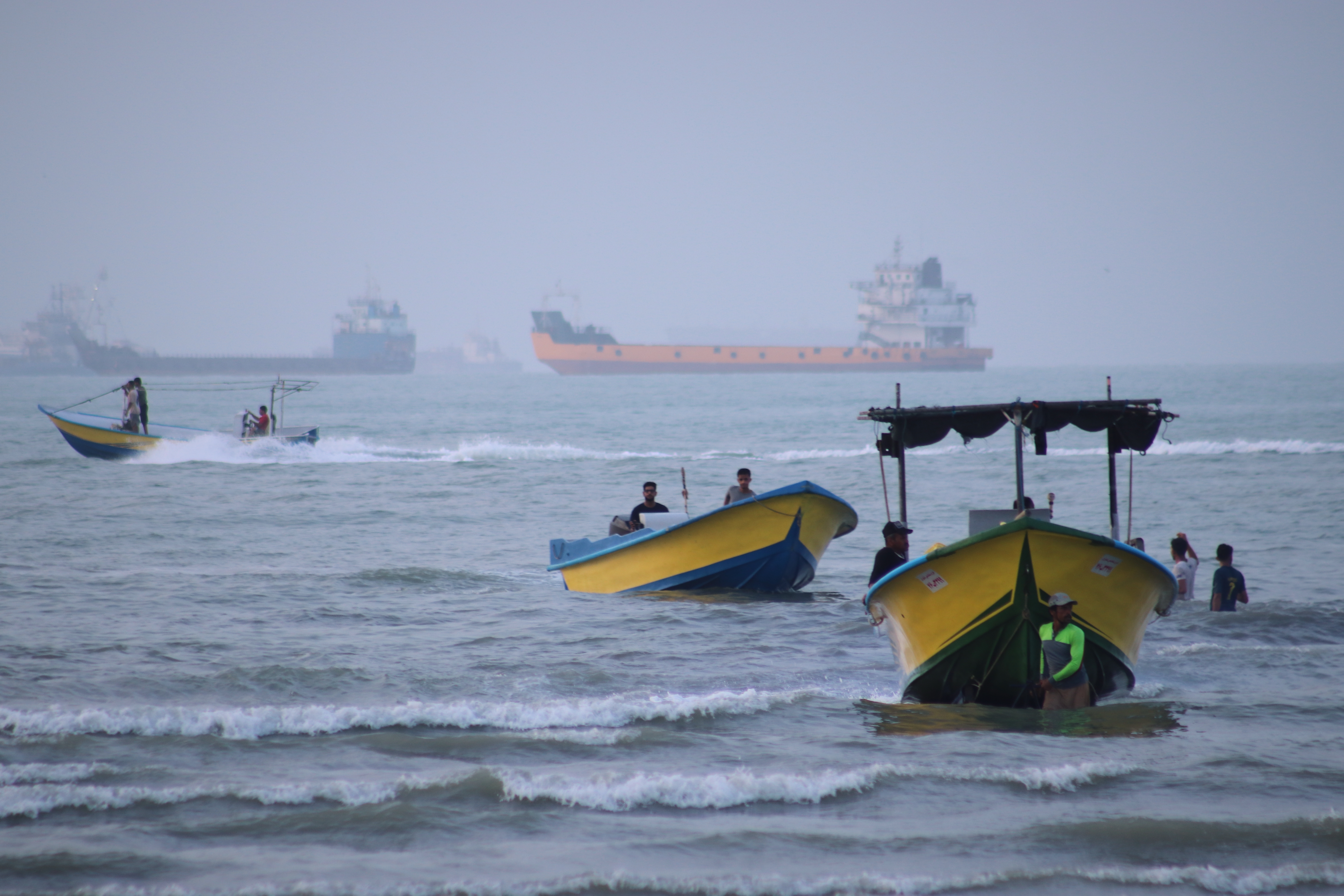 Small boats line the shore as cargo ships and other commercial vessels appear anchored in the Strait of Hormuz in July. (Razieh Poudat/Ap Photo/Razieh Poudat)