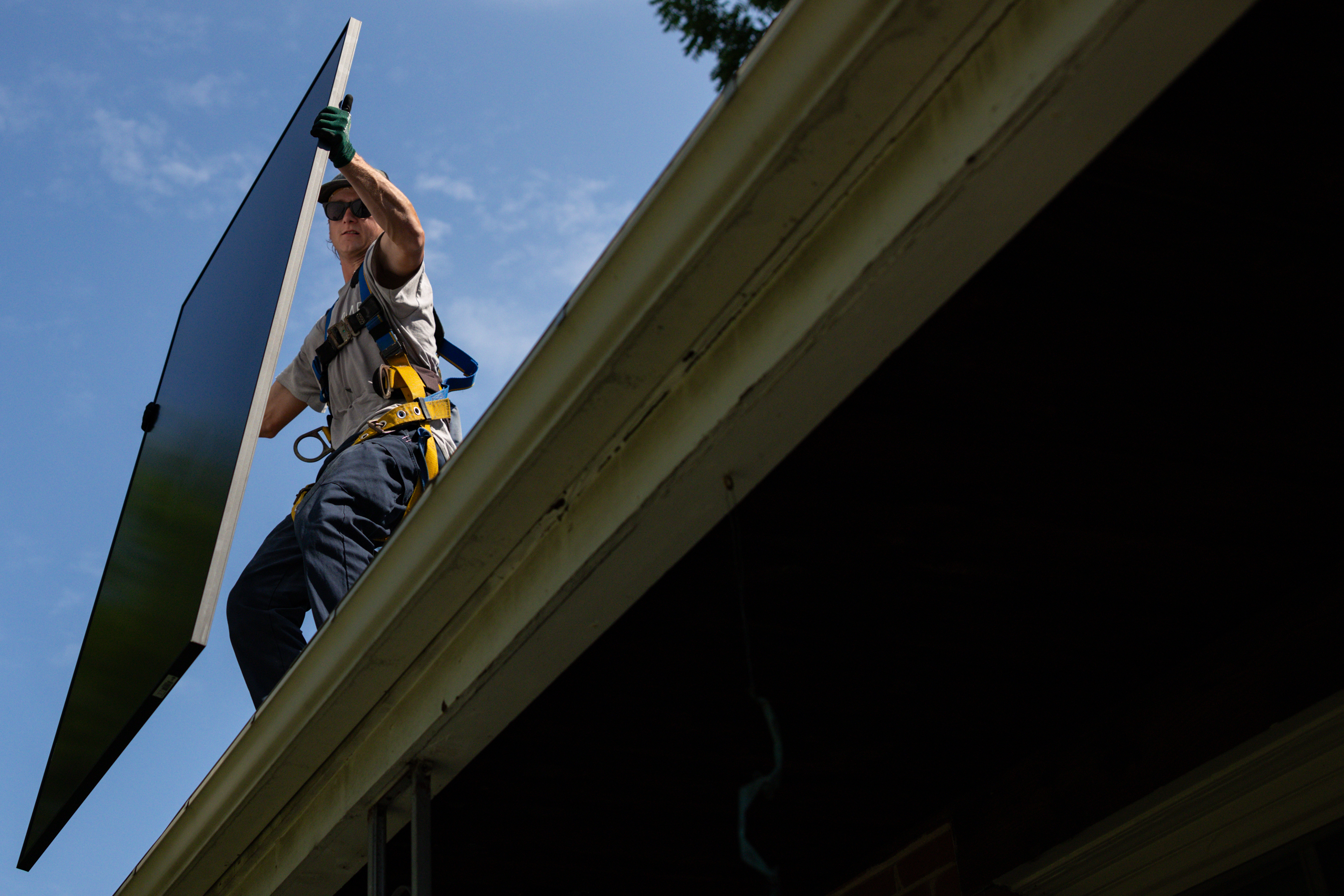 Michael Reimann, an installer with Lumina Solar, adds panels to the roof of a home in Kensington, Maryland, last summer. (Maansi Srivastava/For The Washington Post)
